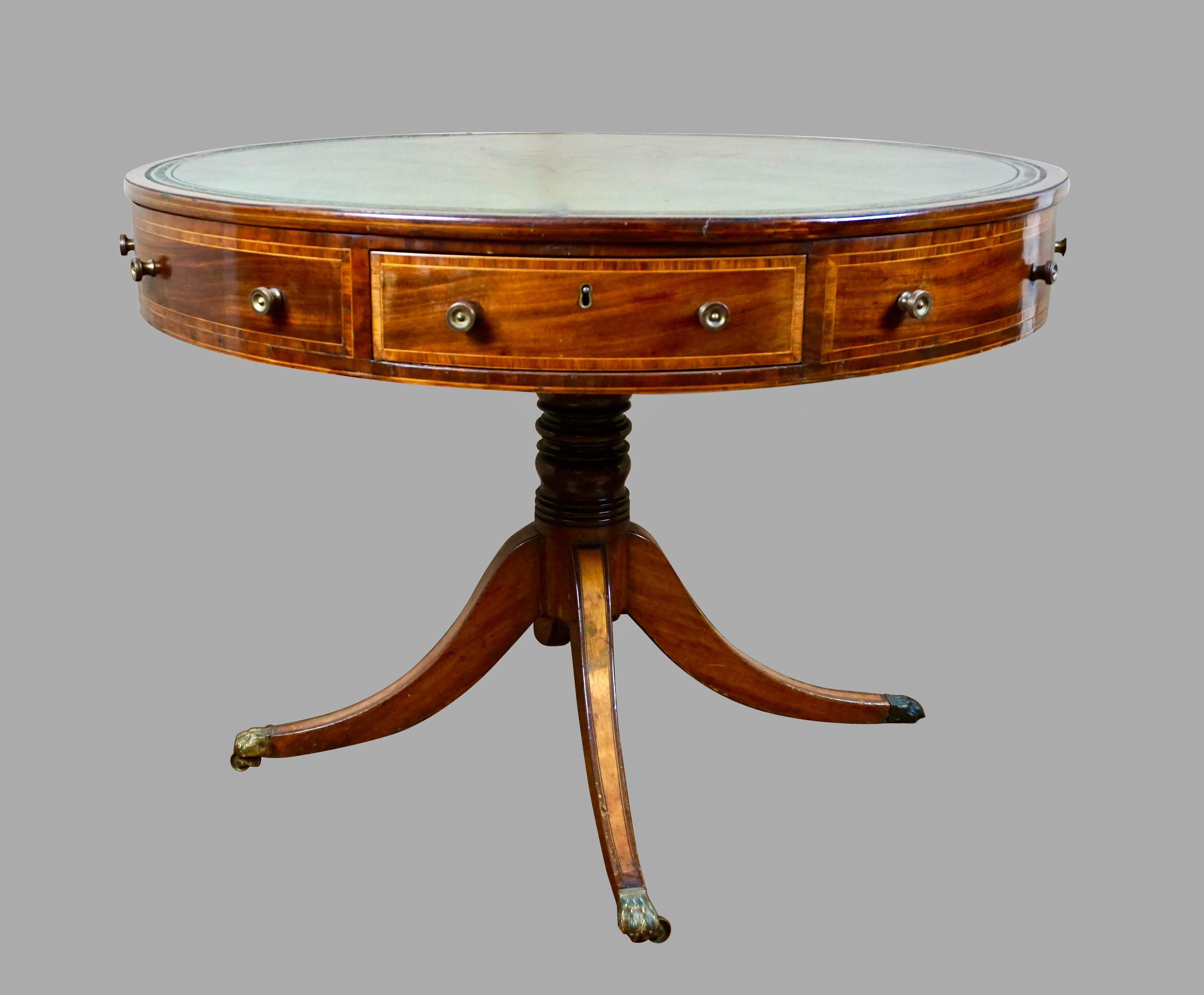 A good quality English late Regency period mahogany drum table, the rotating tooled green leather top over 4 real and 4 dummy drawers, each with satinwood crossbanding. The whole is supported on a tripartite base with satinwood inlaid downswept legs