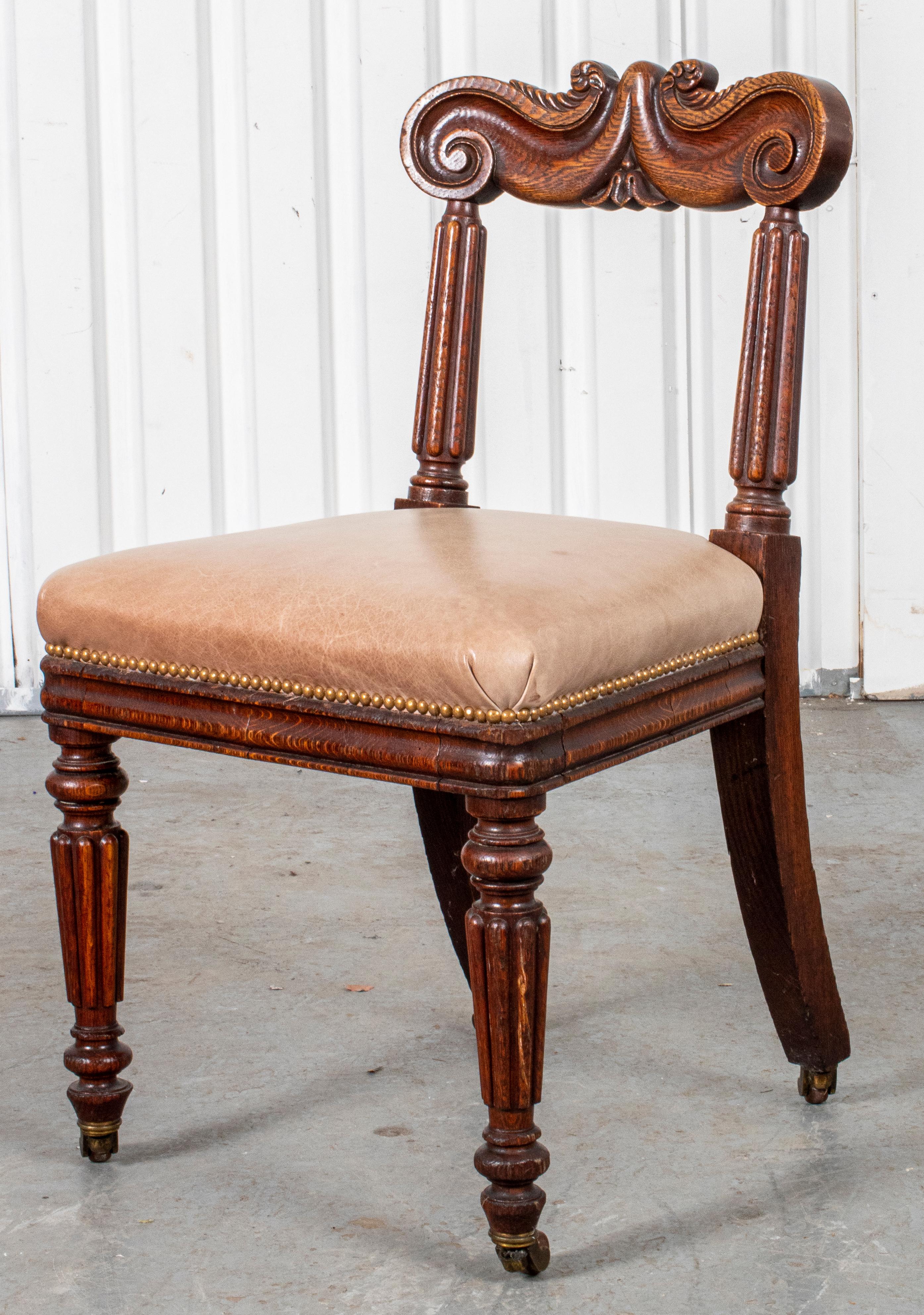 English Late Regency side chair in carved wood, with leather upholstered seat. Measures: 33.5