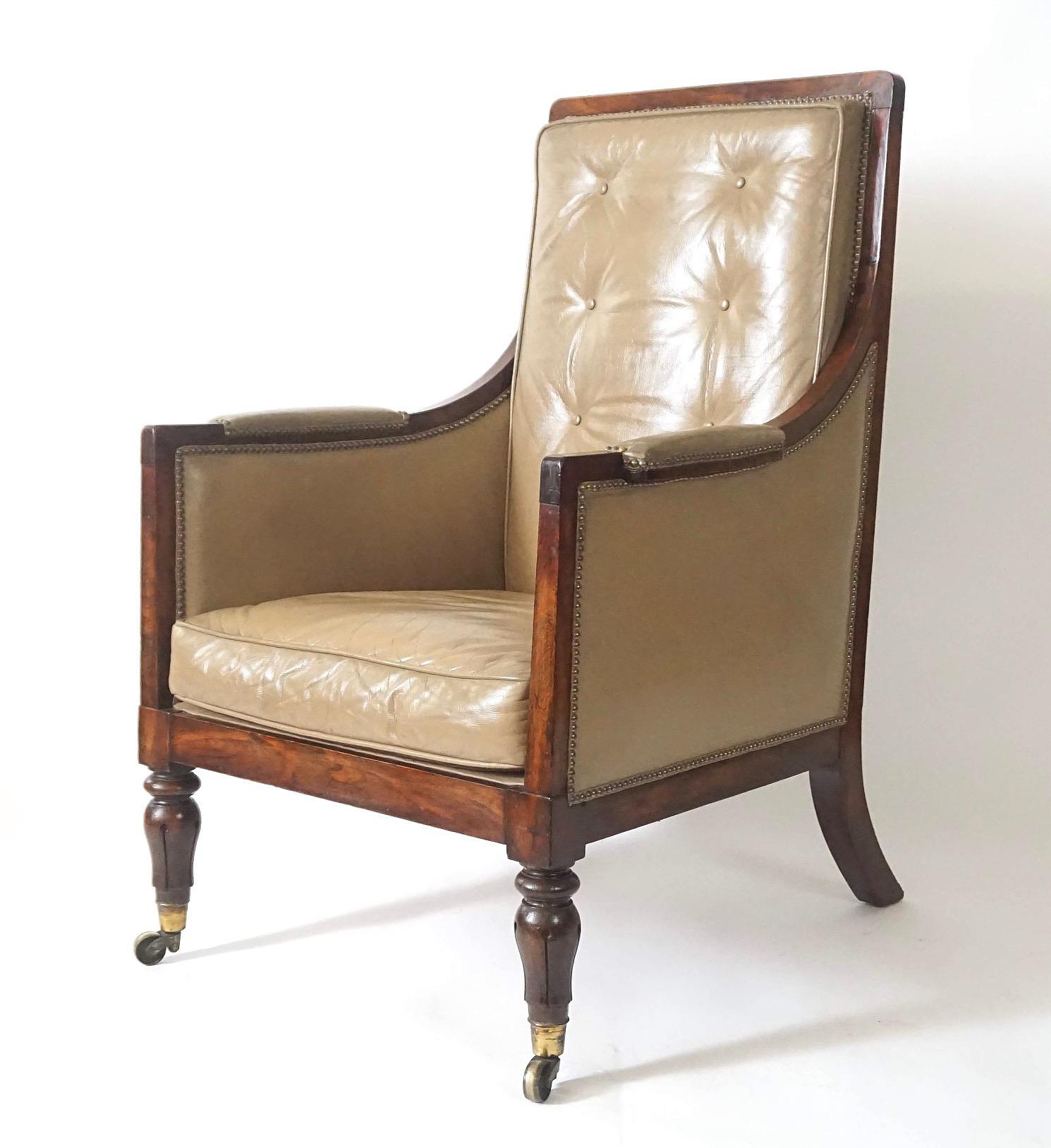 A fine and elegant circa 1835 English late regency William IV period armchair or bergere of large scale and clean design having solid rosewood frame and buff-colored leather upholstery with rectangular tufted back and loose seat cushion either side