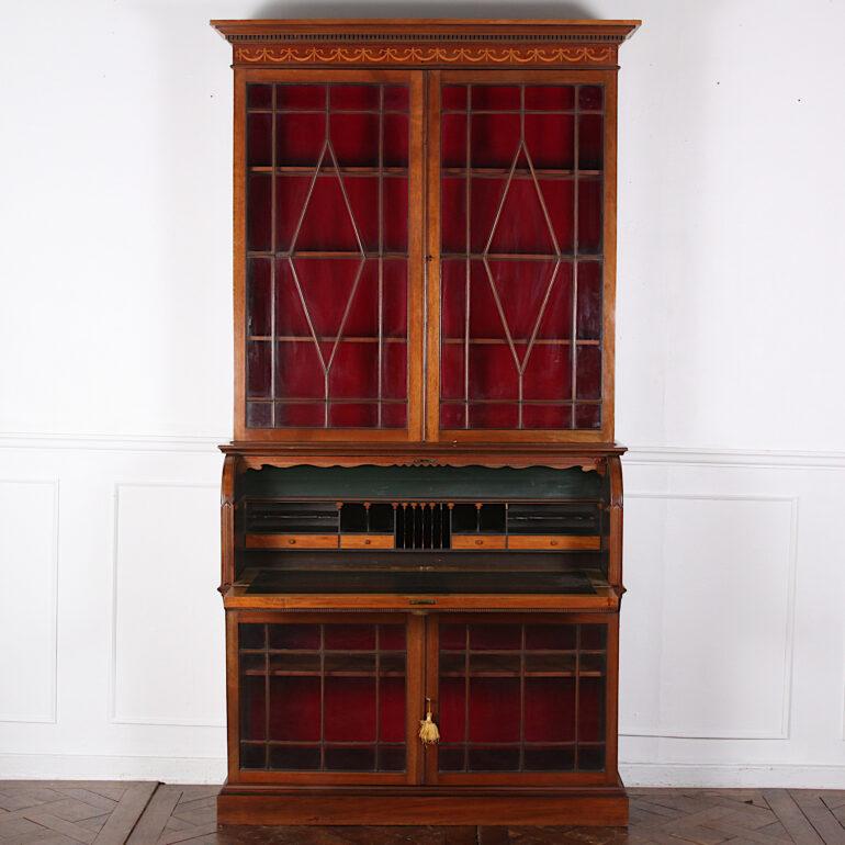 English Edwardian inlaid mahogany secretary bookcase with an unusual mechanical roll-top / drop-front opening to the fitted writing surface. Both top and base with a pair of glazed doors opening to fully adjustable wooden shelves, C. 1900



 