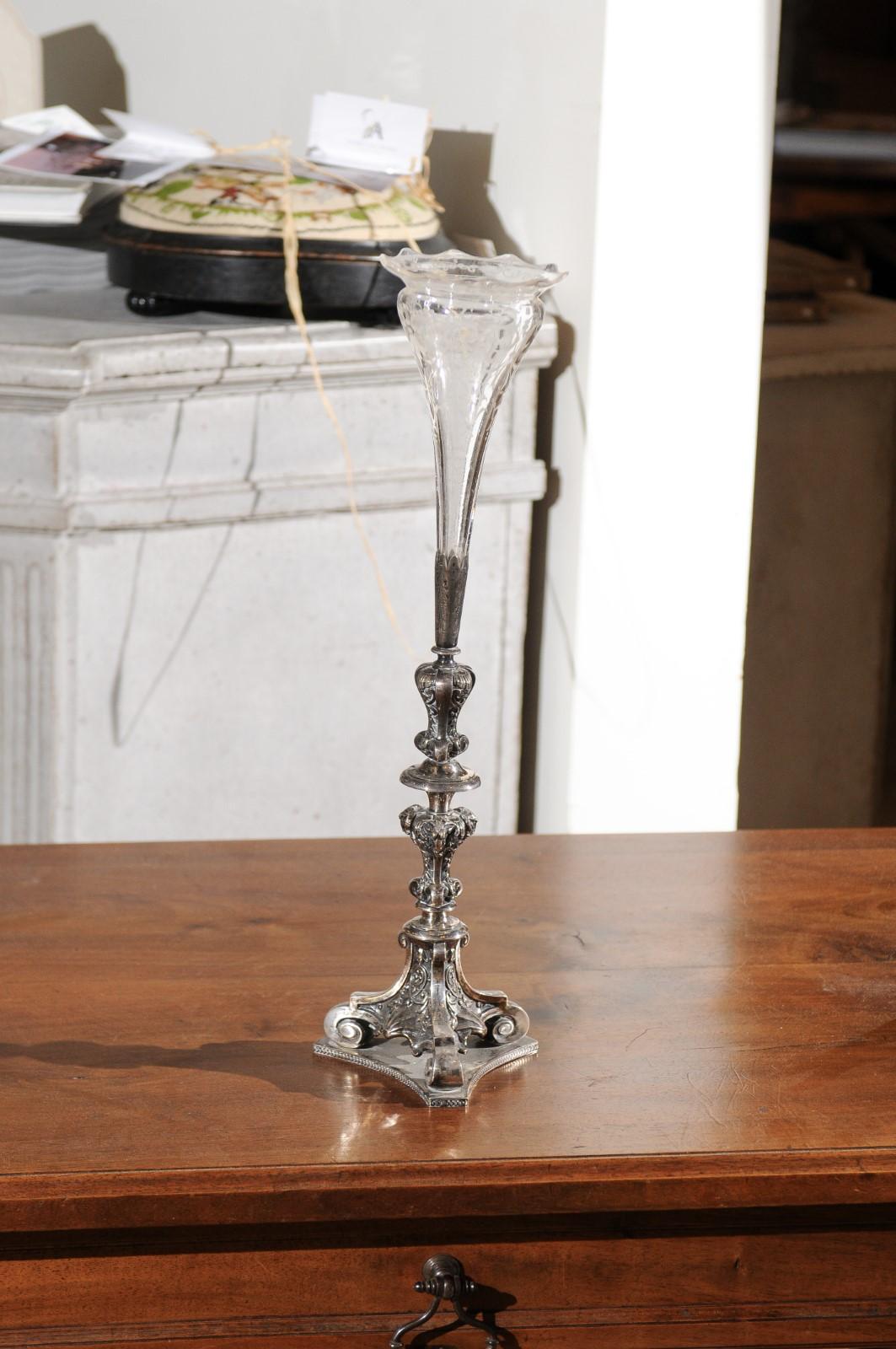 An English late Victorian epergne from the 19th century, with silver base and crystal vase. Born in England during the second half of the 19th century, this exquisite centerpiece features a Rococo inspired silver candlestick with scrolling motifs,