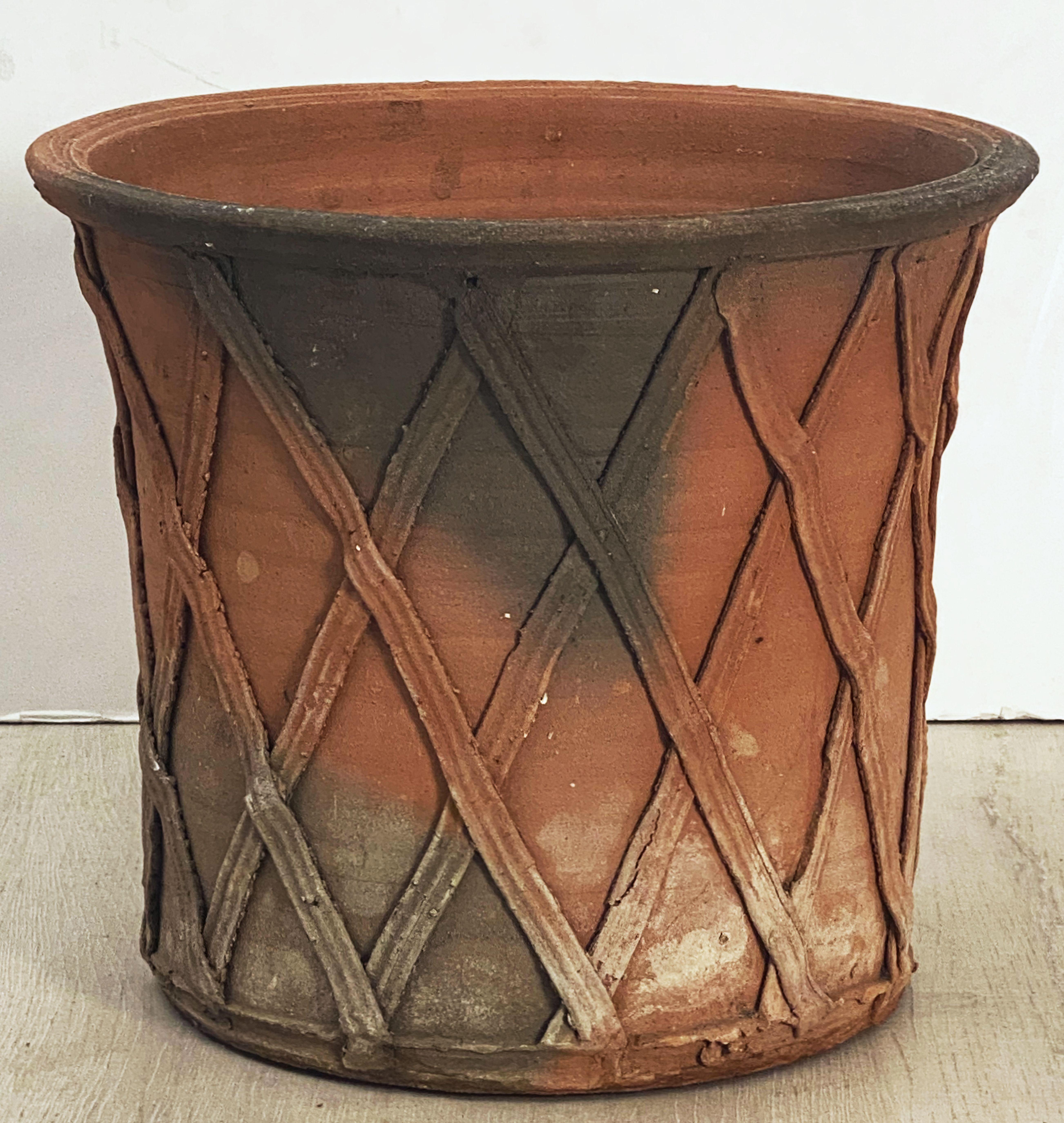 A fine large English round garden planter of terracotta, 14 3/4 inches in diameter, featuring a stylized lattice or strapwork raised relief around the circumference and a rolled edge to the rim.

Dimensions: Height 12 3/4 inches x Diameter 14 3/4