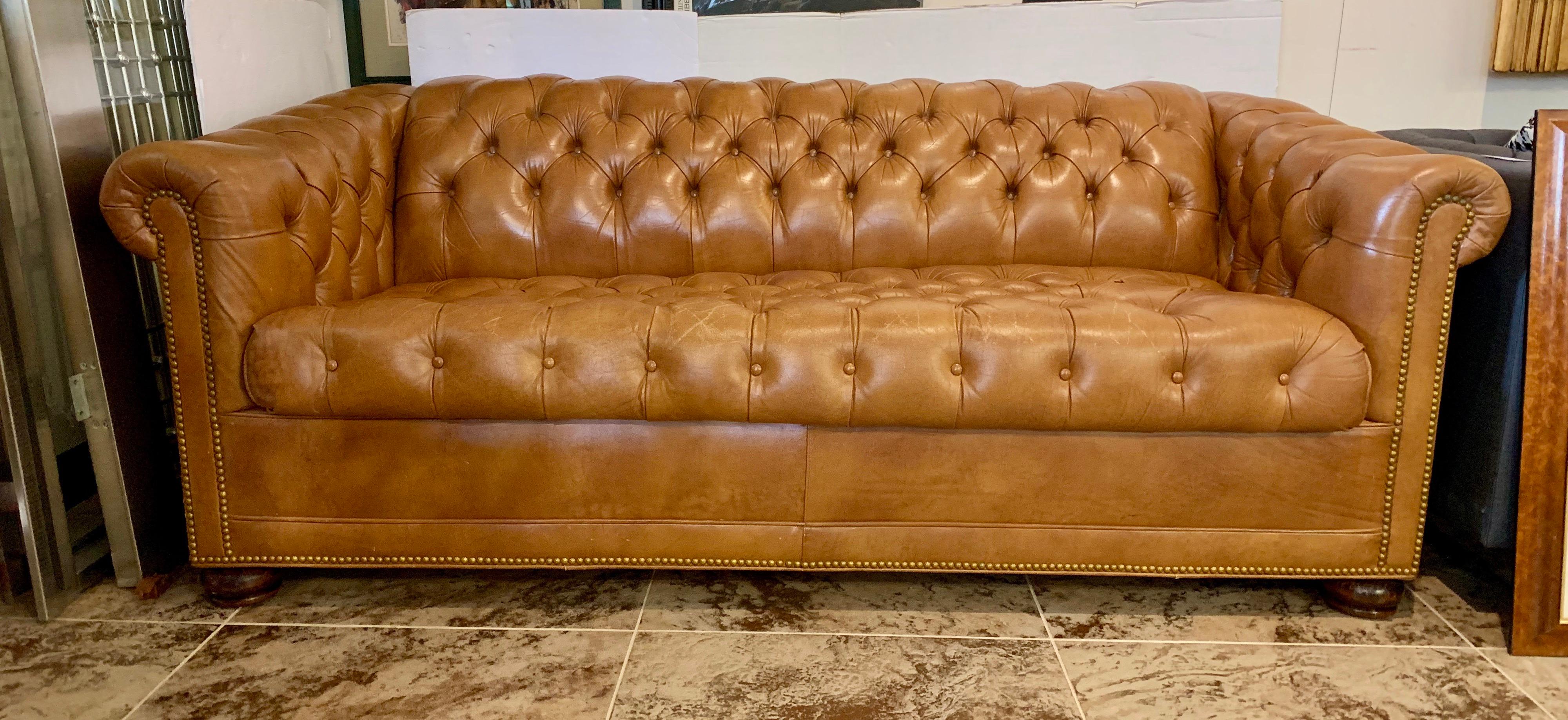 Magnificent caramel leather chesterfield sleeper sofa with nailhead detail and tufted leather throughout. This vintage sofa would compliment a game room, study, or private library. This is a real Chesterfield vintage sofa from England, circa 1960's.
