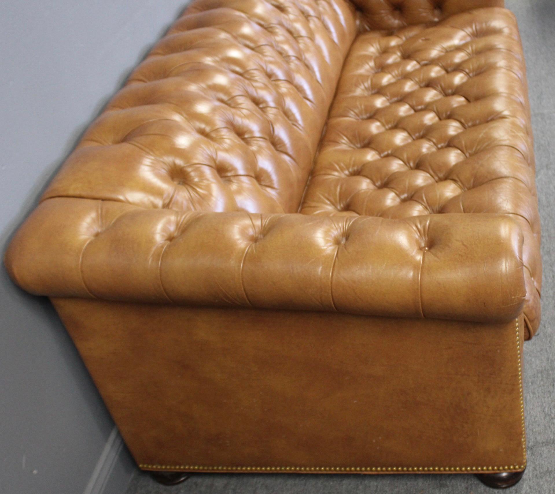 Handsome caramel colored leather chesterfield sleeper sofa with nailhead trim and tufted leather throughout. This vintage sofa would complement a study, game room or library. Sleeper sofa pulls out to a mattress that is 58” wide. Leather has that