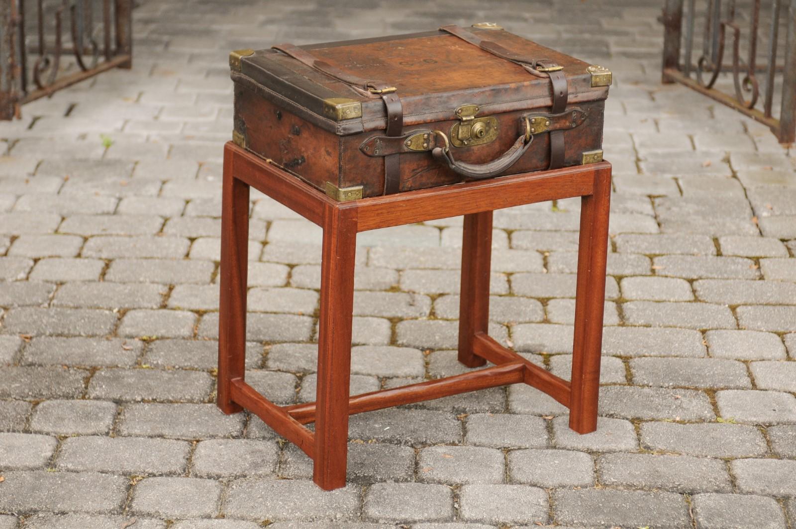 An English leather shell box from the late 19th century mounted on a custom mahogany stand. Born in England during the later years of the 19th century, this handsome piece features a leather shell box presenting a nicely weathered patina, mounted on