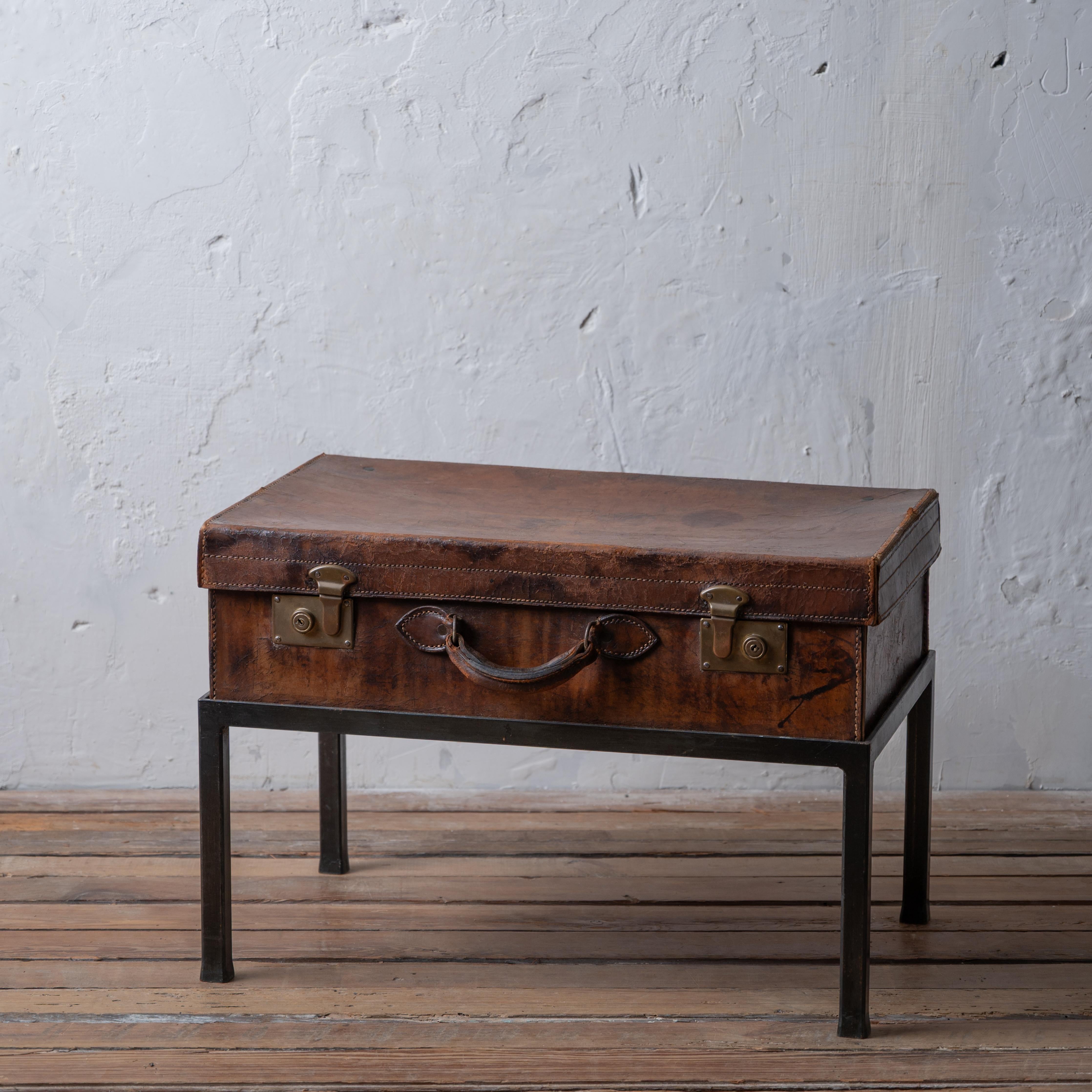 Valise anglaise en cuir sur un support en fer, années 1910.

26 pouces de large par 16 pouces de profondeur par 18 pouces de hauteur


