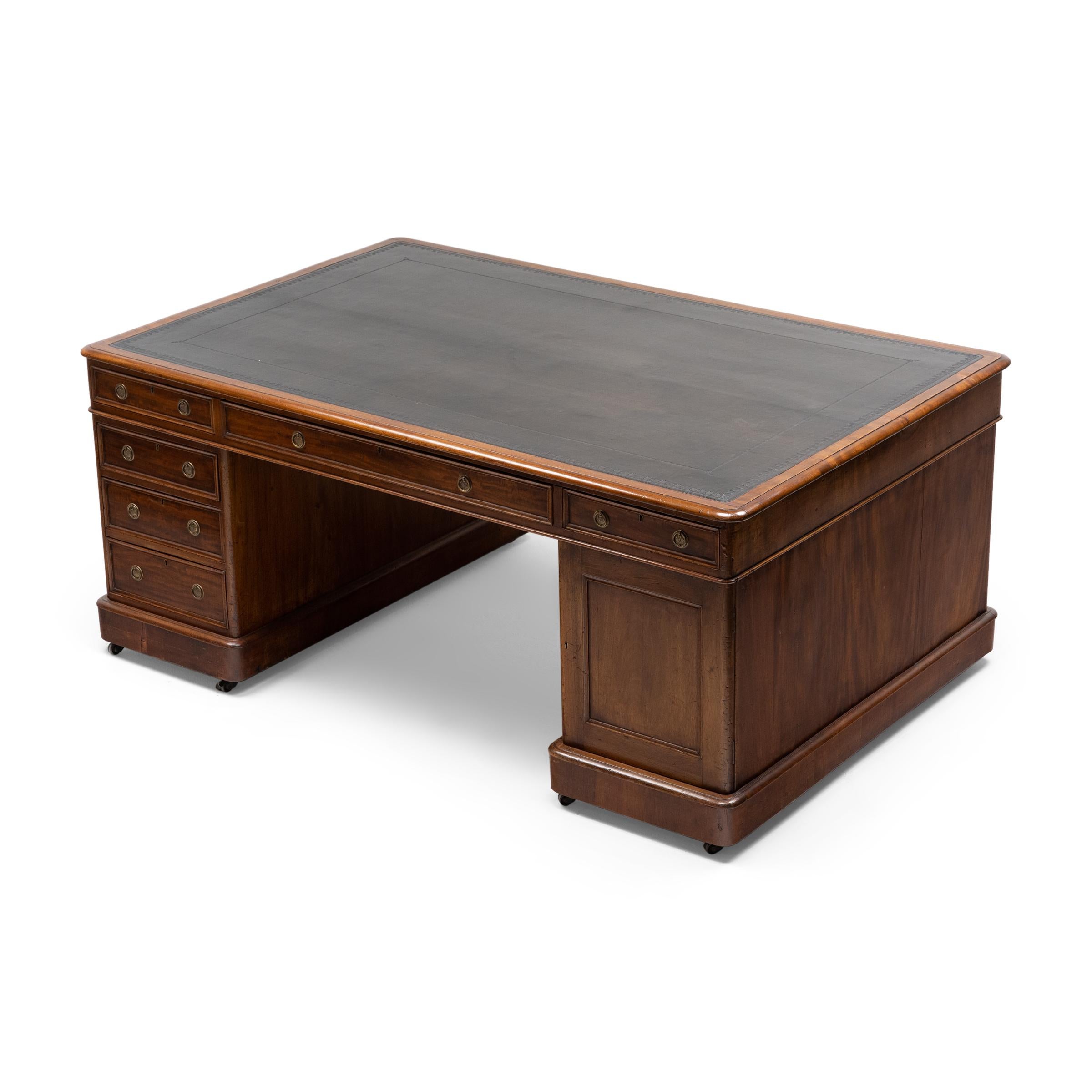 With fine materials and imposing scale, this grand mahogany desk is the ideal centerpiece to a book-lined study or executive's office. The expansive desk dates to the late 19th century and exemplifies a style of office furniture found throughout the