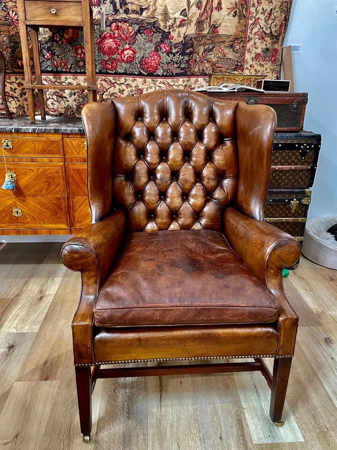 Nineteenth Century English leather tufted wingback chair on walnut legs. Having wide wings and a beautiful form.   In the Georgian Style.

