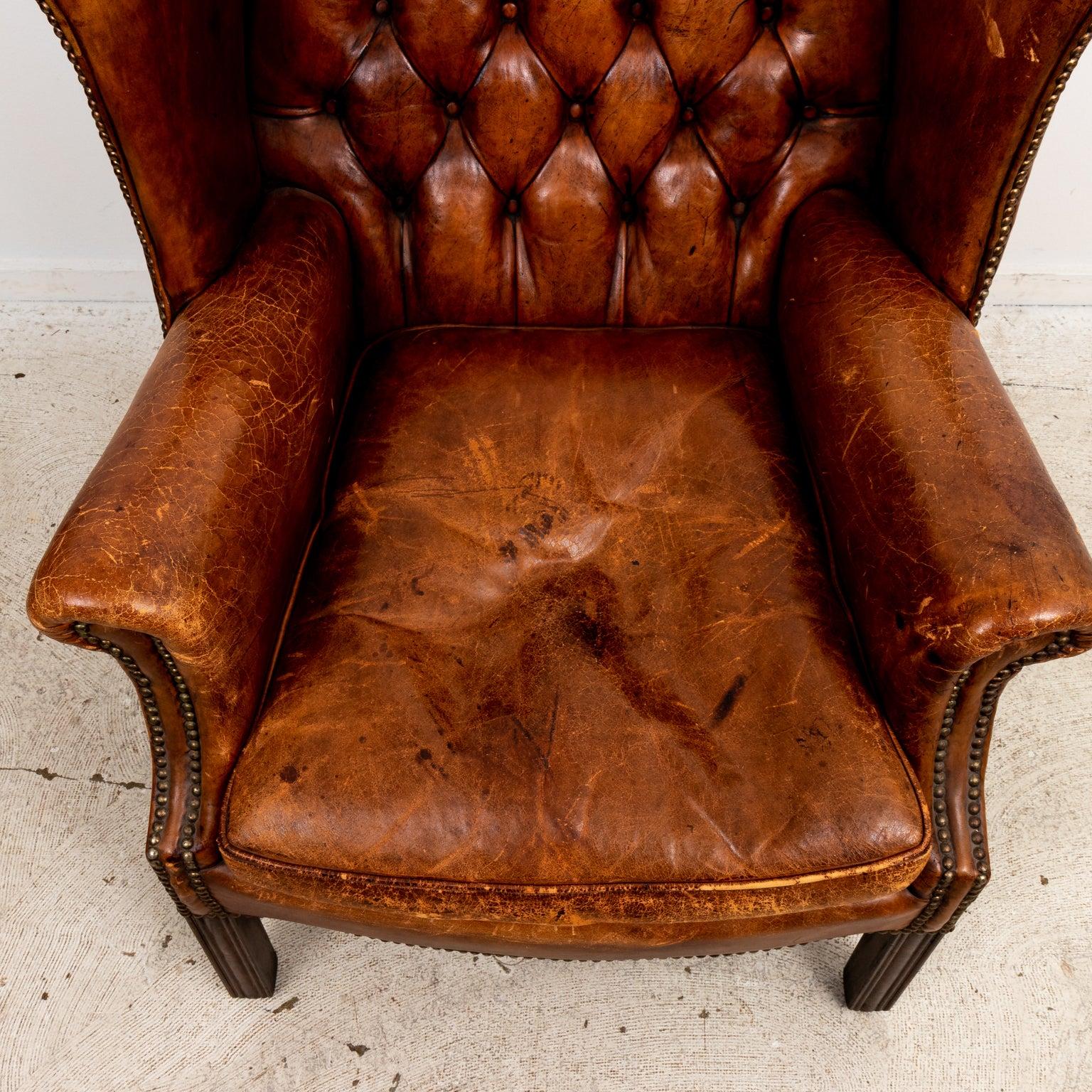 English Chippendale style tufted back wing chair in camel colored leather. Please note of wear consistent with age.