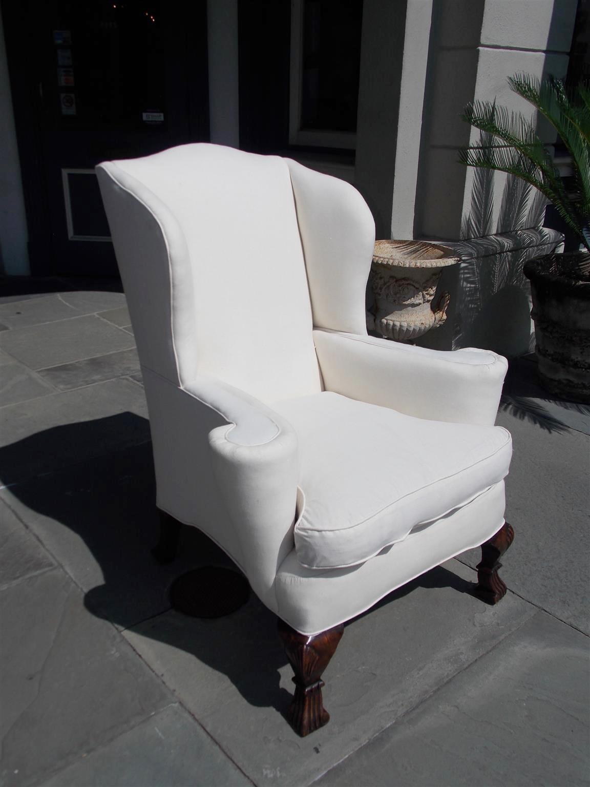 English walnut upholstered wing back chair with scrolled arms, carved shell knee, and terminating on Spanish feet, Chair is upholstered in white muslin with removable cushion,  Mid 18th century.


 