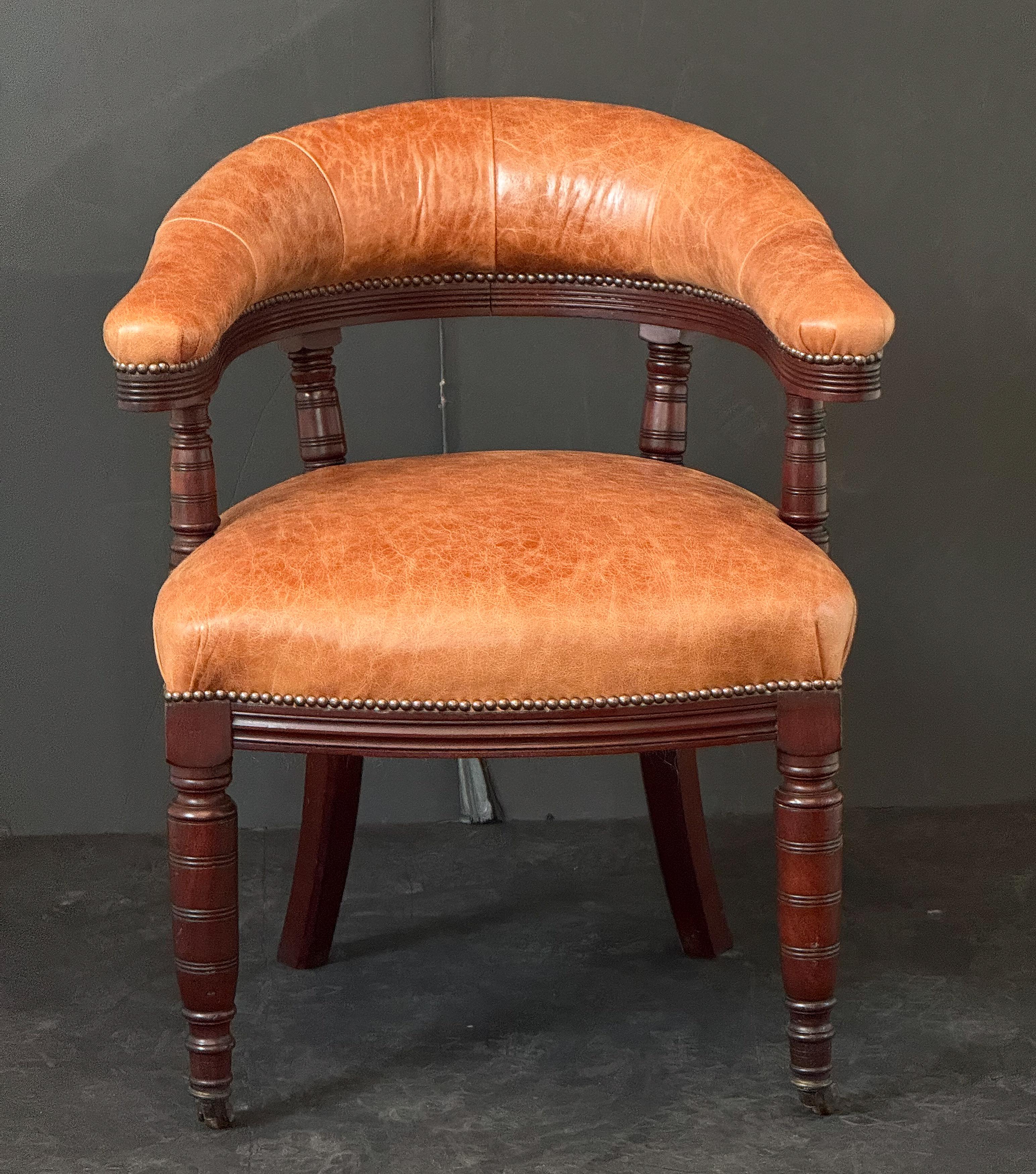 Fauteuil de bibliothèque ou chaise longue en acajou de style George III d'Angleterre, présentant un haut dossier en cuir rembourré, une large assise confortable en cuir rembourré, des côtés ouverts, des accoudoirs en forme, sur un brancard avec une