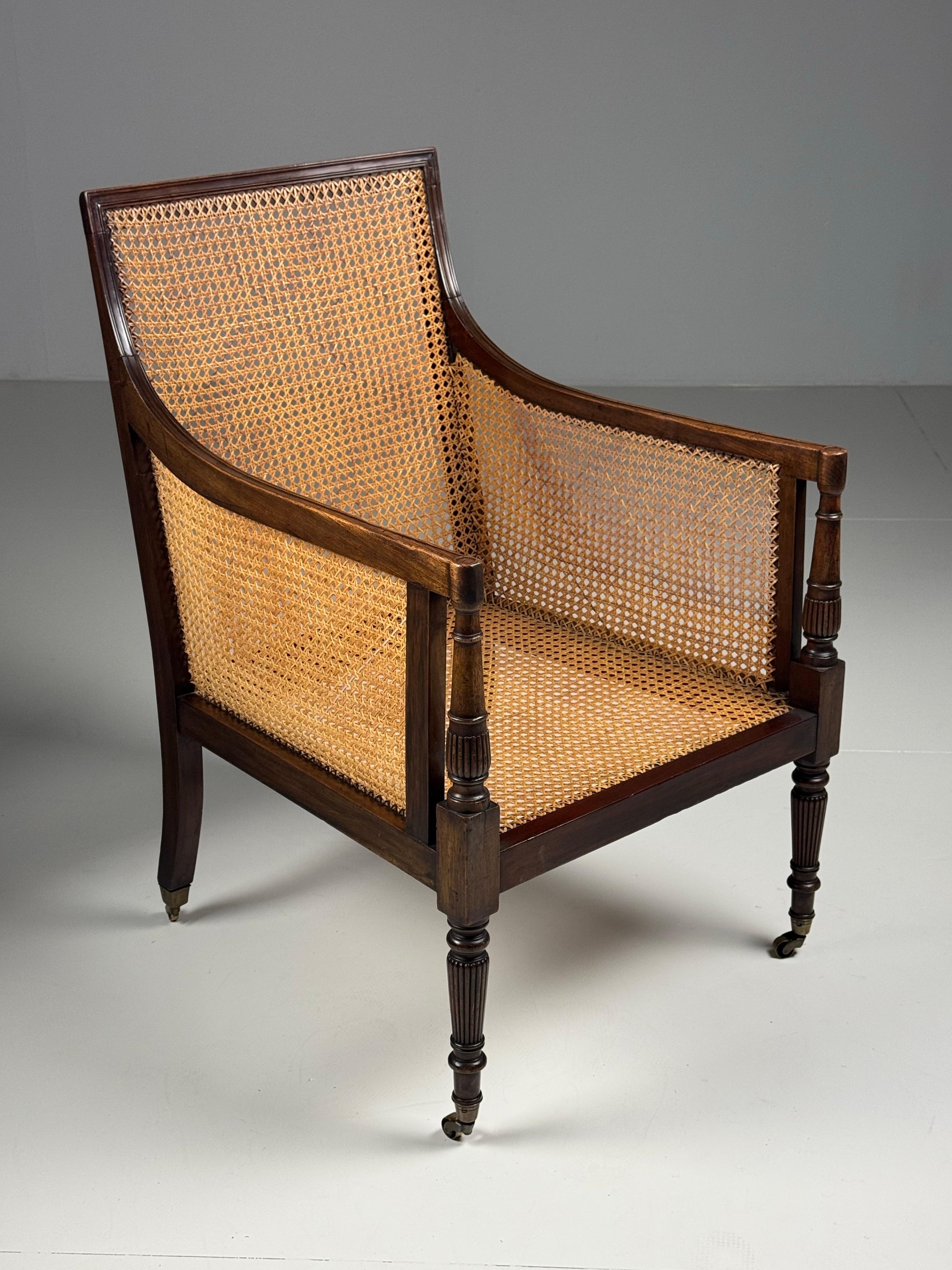 Exceptionally beautiful English Library Bergère chair.

Executed in mahogany. Standing on brass castors. Original from England, George IV period (1825).

In very good condition. Leather and wicker seat are not from this period but replaced