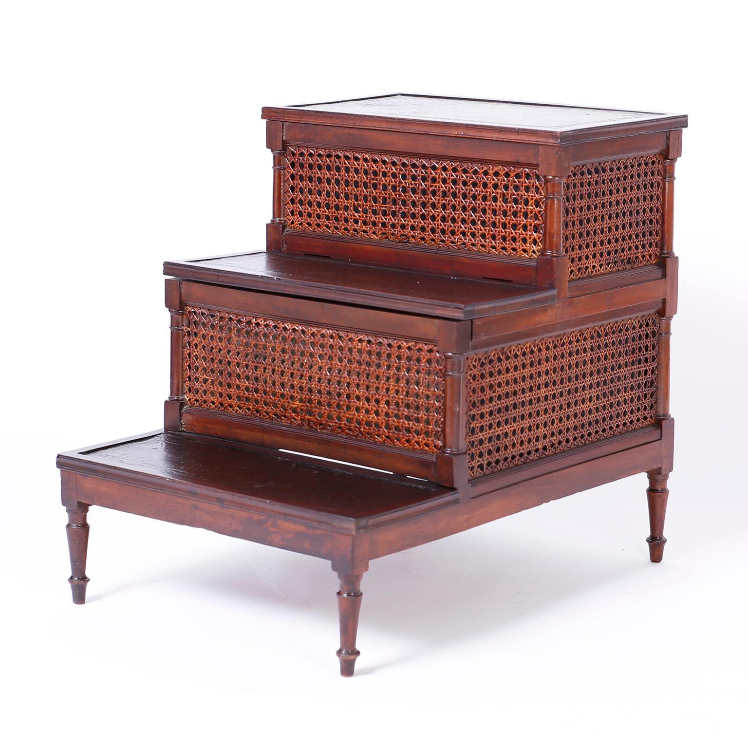 English mahogany library stairs retaining its original tooled brown leather steps, hand caned panels, elegant turned legs, and surprising hidden storage.