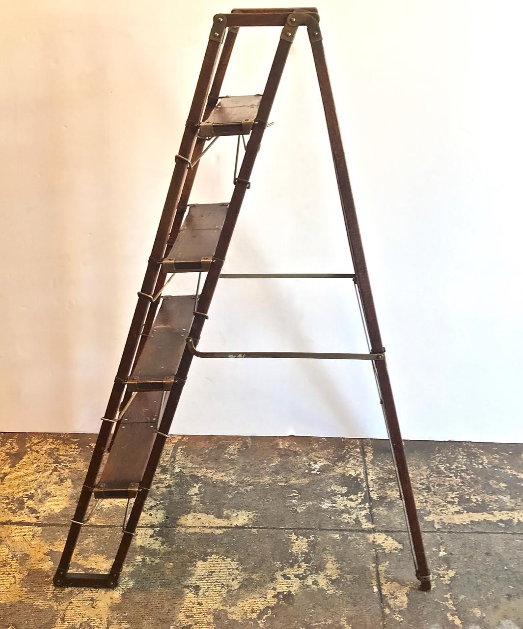 This is a charming foldable English set of library steps that dates to the late 19th century or early 20th century the oak steps are fitted with the original brass supports. The steps are in overall good condition and are stable for this type of