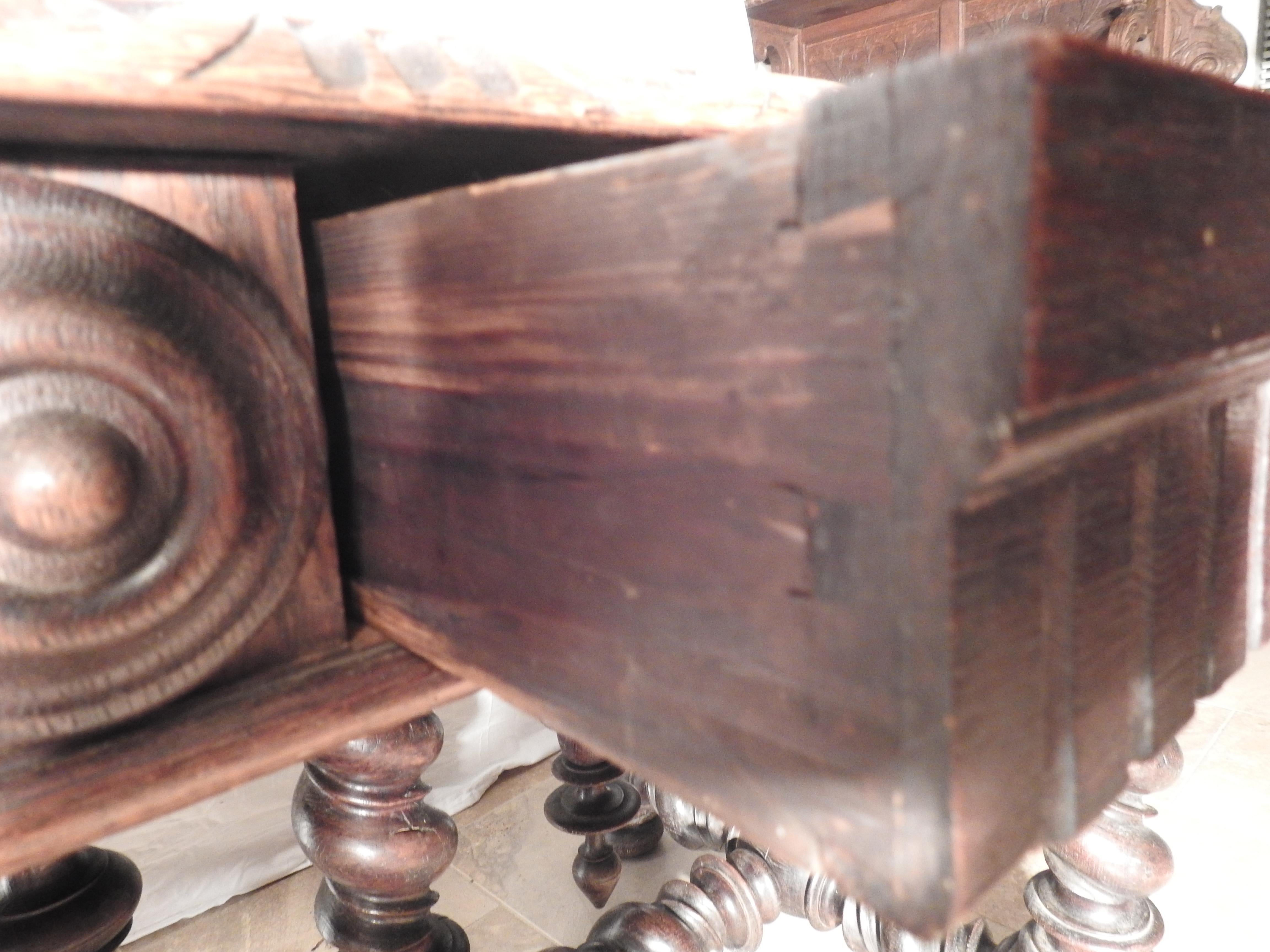 Offering this unmatchable English library table. Having barley twist legs and stretchers this table has a substantial base it sits atop. Around the edge of the table it has medallions and two drawers to one side. Made of walnut and stained in a dark