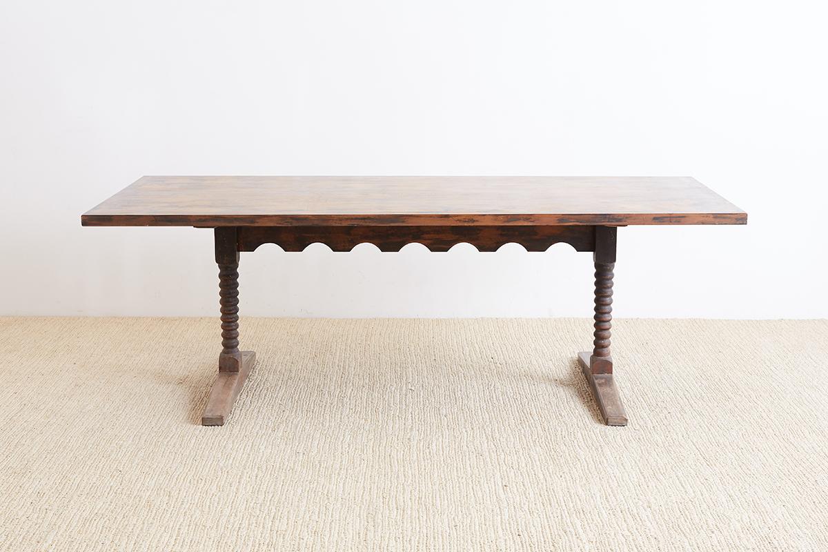 Rare and unusual 19th century English trestle library table or refectory table made in the Spanish Colonial taste. The walnut rectangular top is supported by two bobbin turned pillar legs ending with large trestle style feet. The legs are conjoined