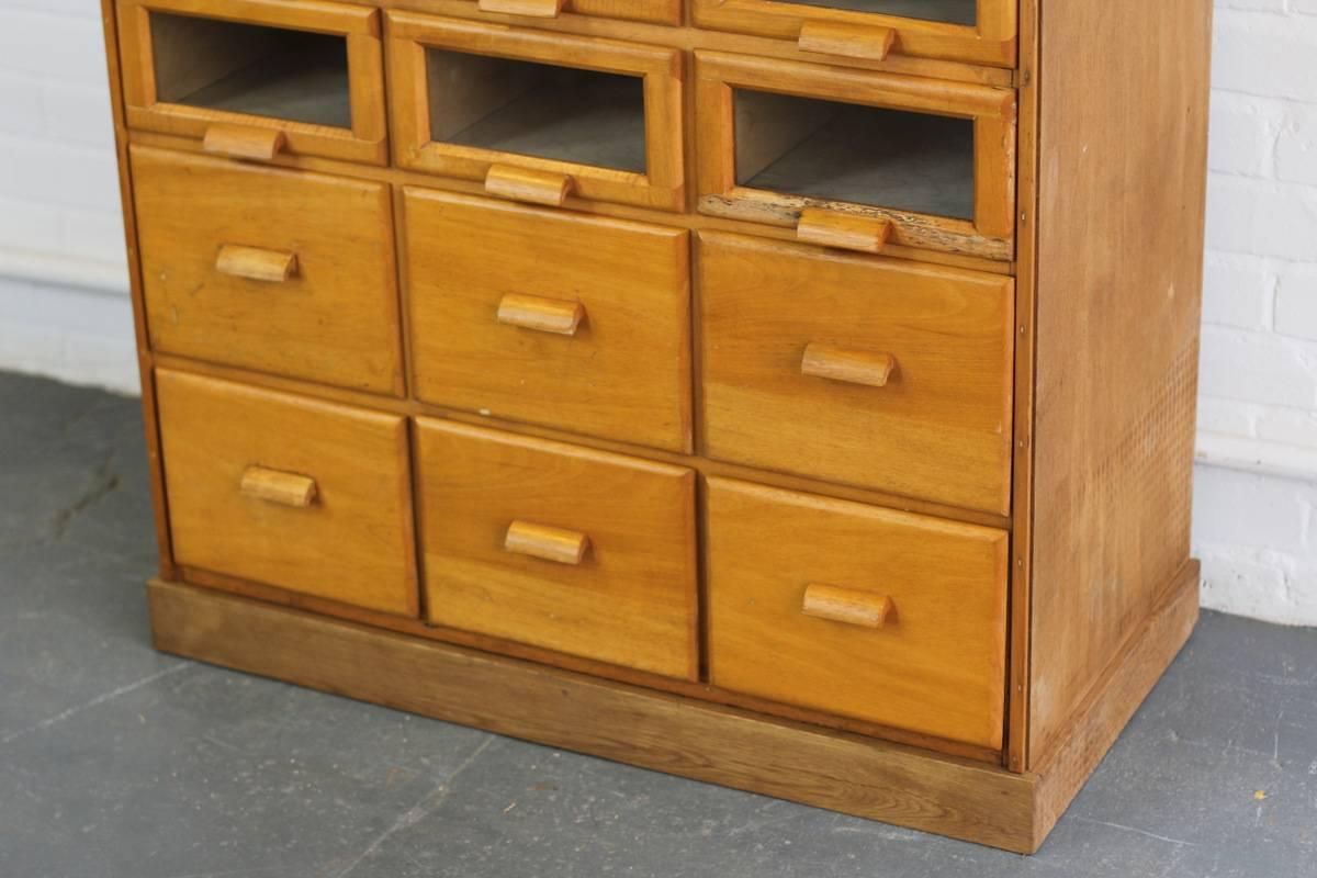 English light oak Haberdashery cabinet, circa 1940s

- 24 glass front drawers
- Six larger solid drawers
- Shaped oak handles
- Beautiful reeding detail to the top skirting
- English, circa 1940s
- 94cm wide x 47cm deep x 199cm