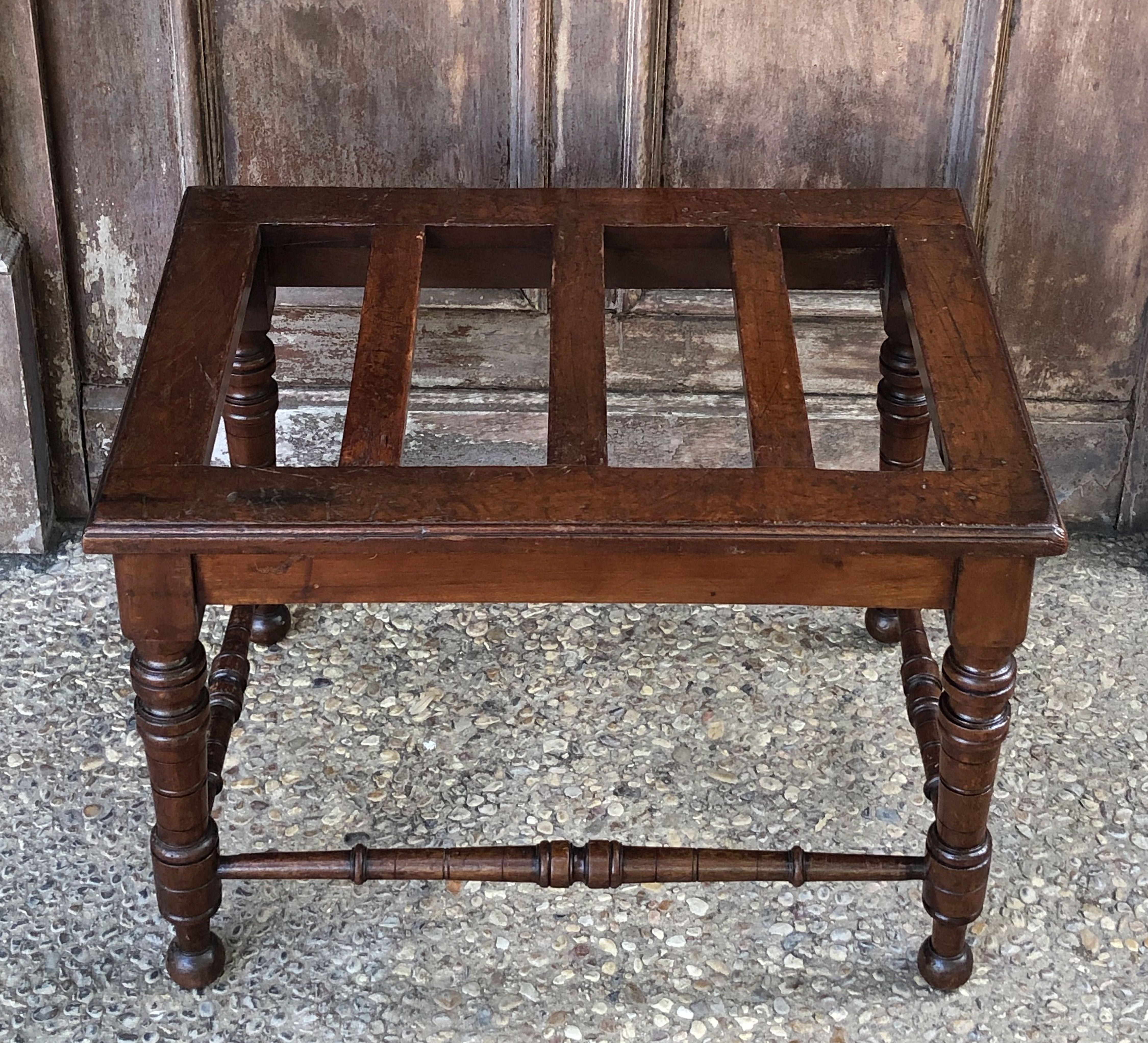 A fine English luggage rack or rectangular low table of mahogany, featuring a top of wooden slats over a support of four turned legs, with turned stretcher. Can be used as a stool as well.