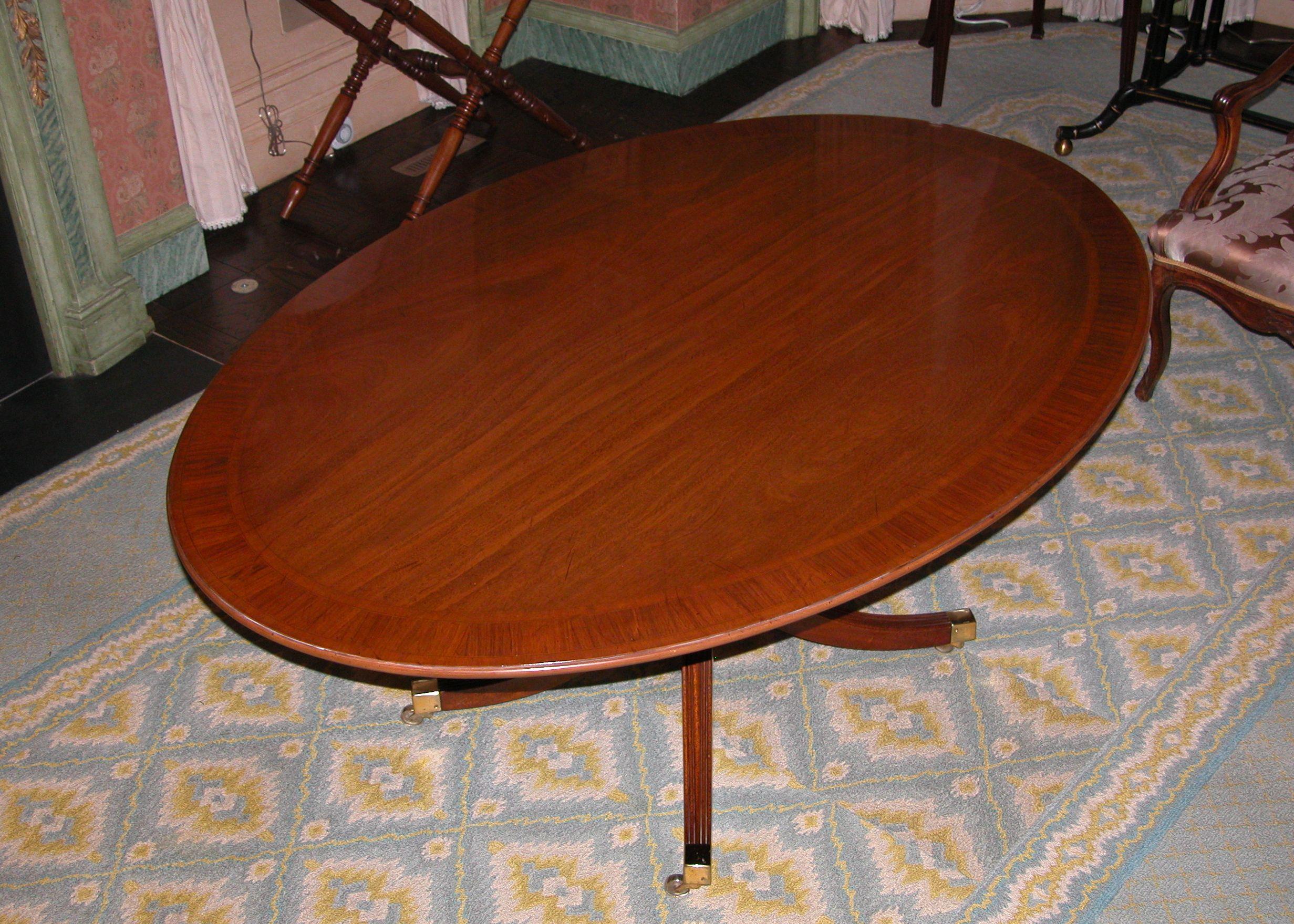 Oval English bench made mahogany table on single pedestal base with cross banded top. This is a wonderful size and can be used as a dining room table, breakfast room or even as a conference room table. Purchased in 1962 from Wood & Hogan in New