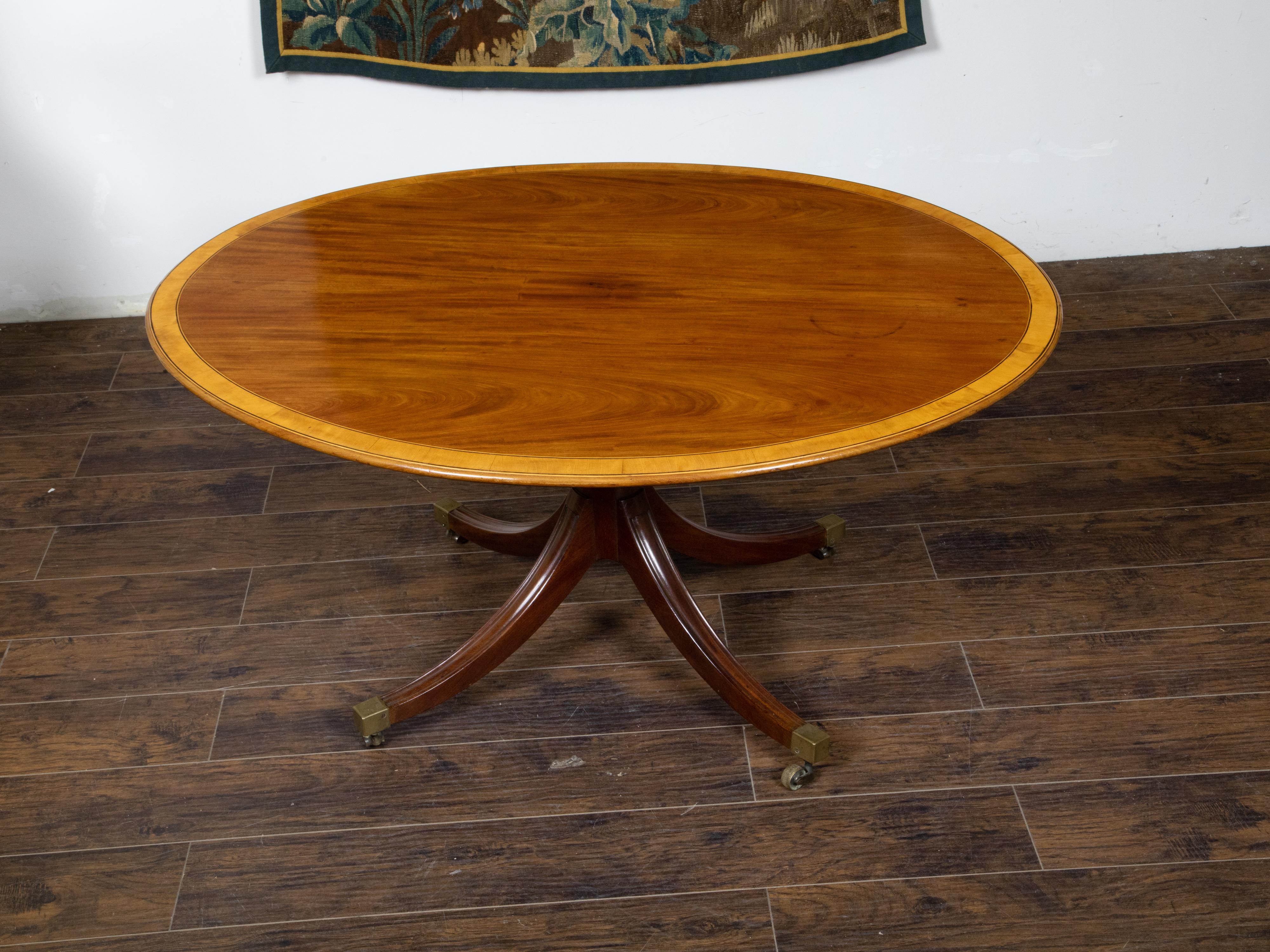 Brass English Mahogany 1840s Oval Top Pedestal Table with Quadripod Base and Casters For Sale