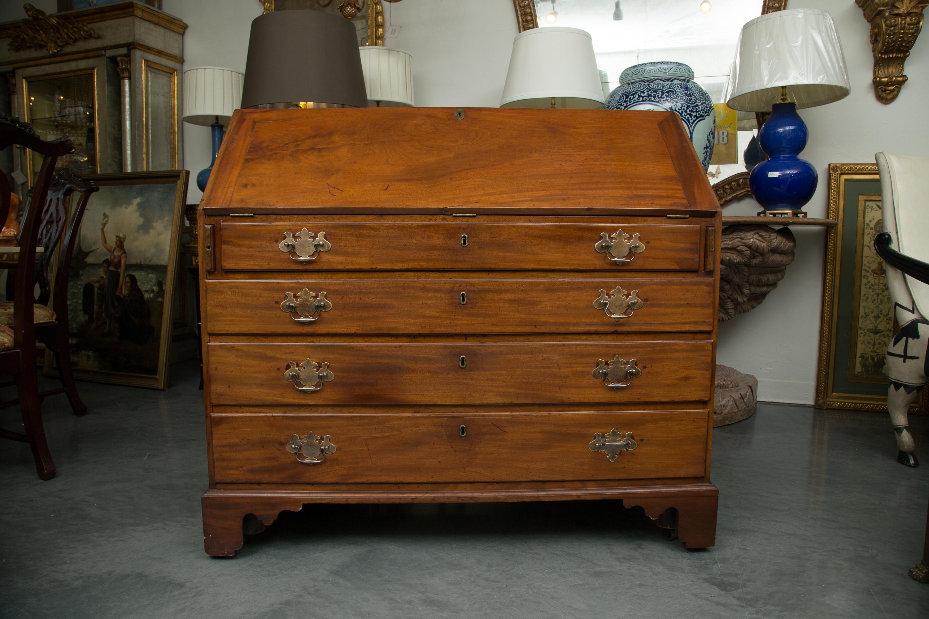 This is a Classic George III mahogany slant top desk. The slant front drops to reveal a series of small drawers and document compartments over four long graduated drawers and raised on bracket feet, circa 1790.
