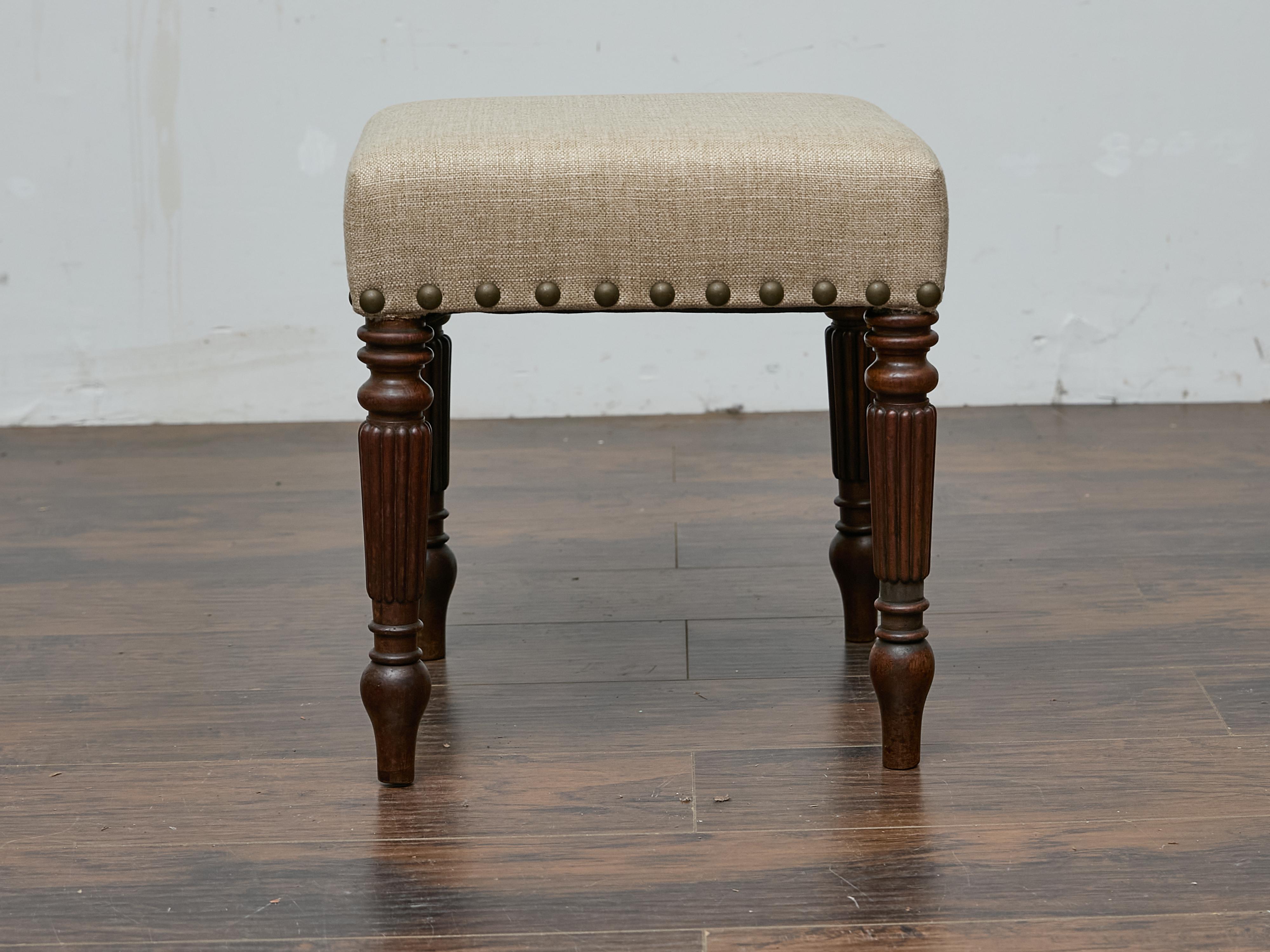 Radicato nell'artigianato inglese del XIX secolo, questo sgabello in mogano bilancia raffinatezza e funzionalità con la sua presenza scolpita. Il legno riccamente patinato mette in mostra gambe tornite con dettagli ribattuti, che si assottigliano in