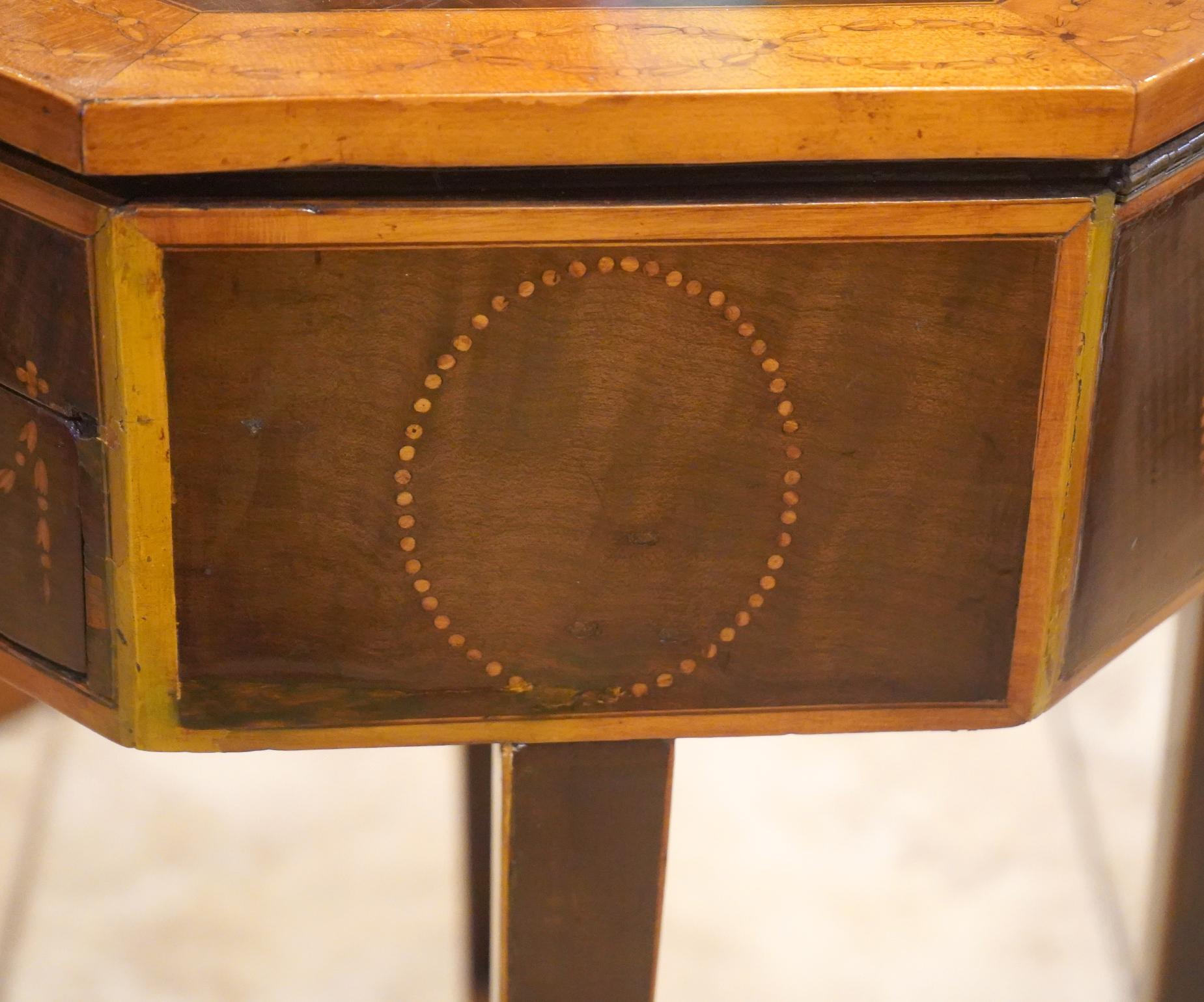 Table de couture à 3 tiroirs en acajou anglais avec de magnifiques incrustations de motifs floraux en bois de satin, construction à queue d'aronde, poignées en laiton sur les tiroirs et dessus octogonal à charnière

Utilisé, Bon état, Voir toutes