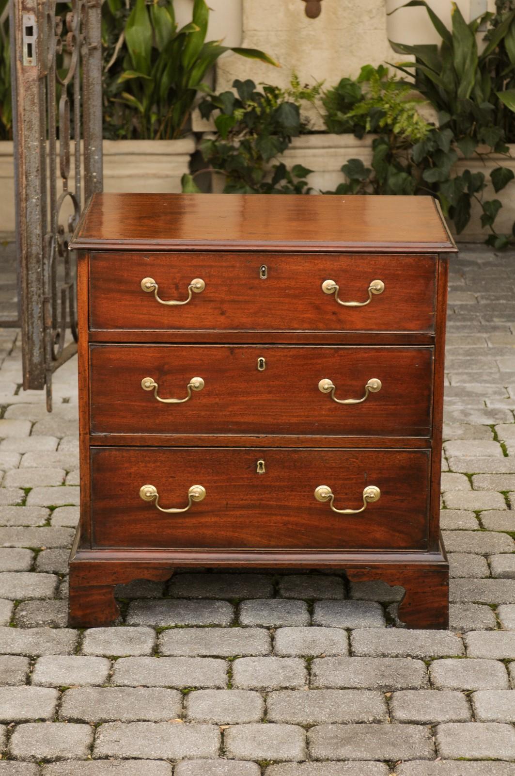 An English mahogany bachelor's chest from the mid-19th century, with three drawers, brass hardware and bracket feet. Born in England during the third quarter of the 19th century, this exquisite bachelor's chest features a rectangular top with molded