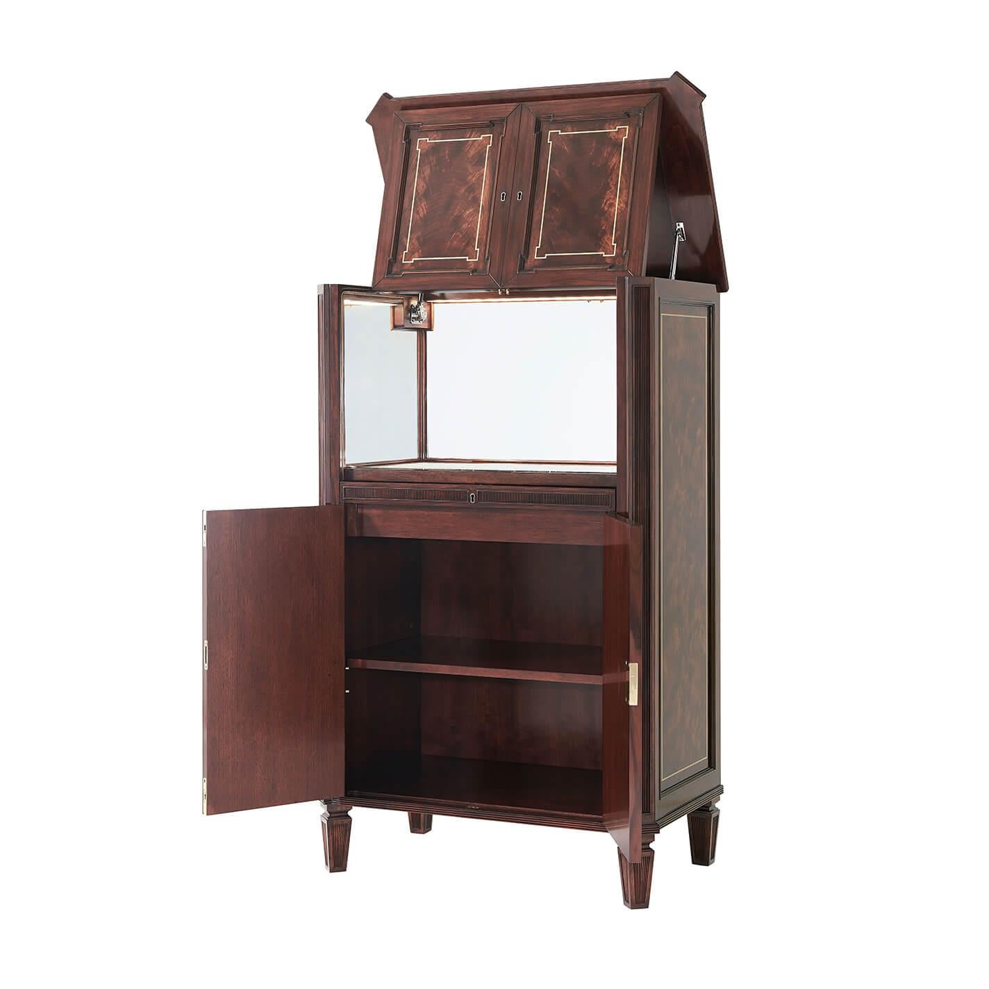 A fine English Georgian flame veneered, mahogany and brass inlaid bar cabinet, the lockable hinged top and faux cabinet front opening to reveal a marble and mirrored interior, the canted paneled angles enclosing a frieze drawer and two cabinet doors