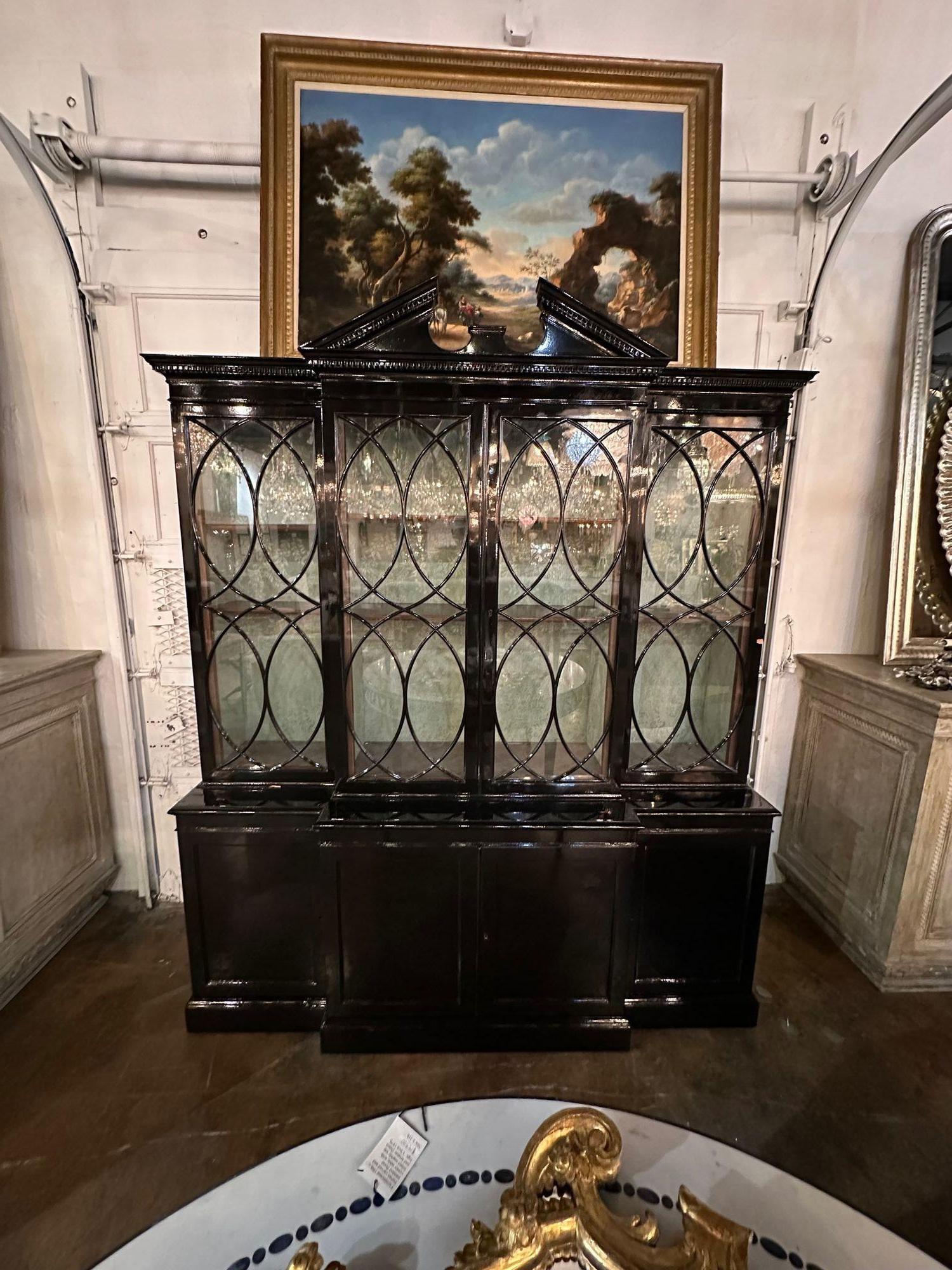 Handsome English mahogany black lacquered breakfront display cabinet. A very fine piece for a traditional home.