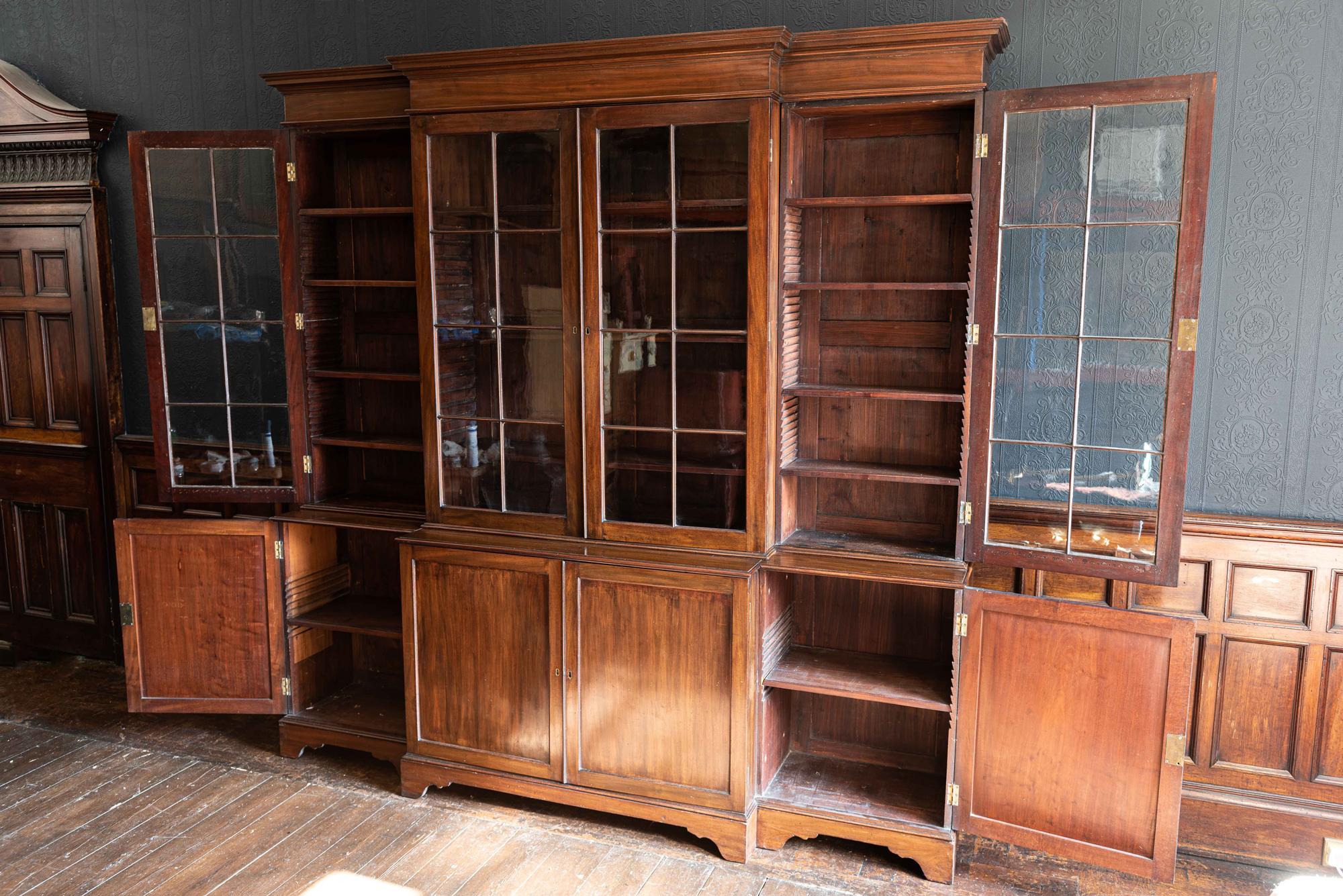 English mahogany breakfront library bookcase,
circa 1900.

Stepped cornice and fitted with adjustable shelves enclosed four glazed and four paneled doors, bracket feet. All original including hand blown glass, brass locks, separates into 6