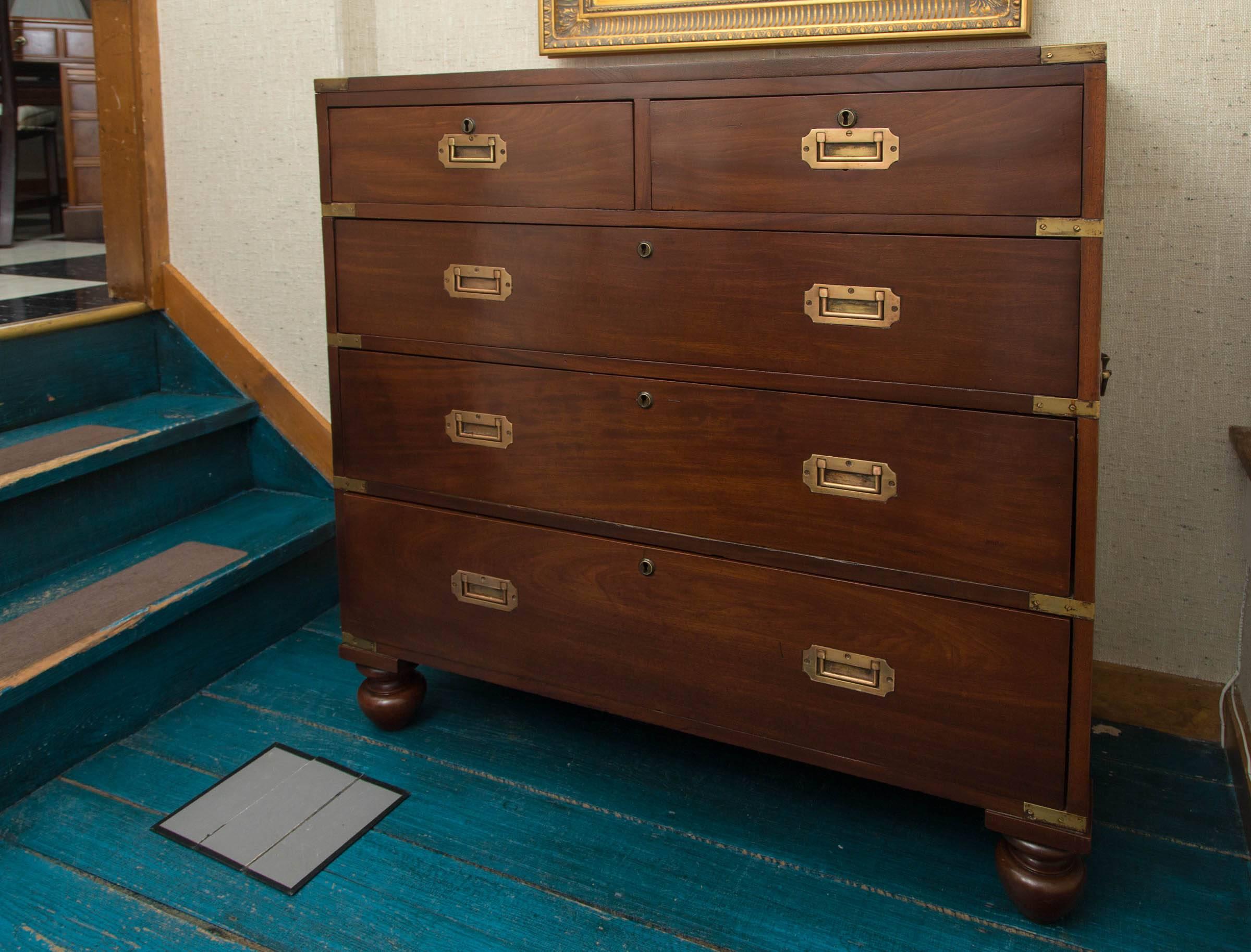 One-piece English mahogany campaign chest of drawers with single set of brass handles. Chest rests on replaced bun feet.