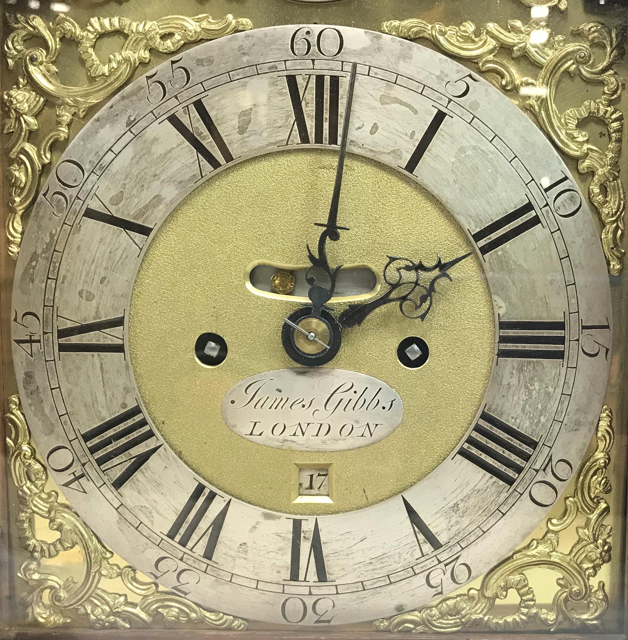 A beautiful 18th century mahogany case bracket clock with arched glazed glass door opening to a 12 inch brass dial with ebonized Roman numerals, signed 