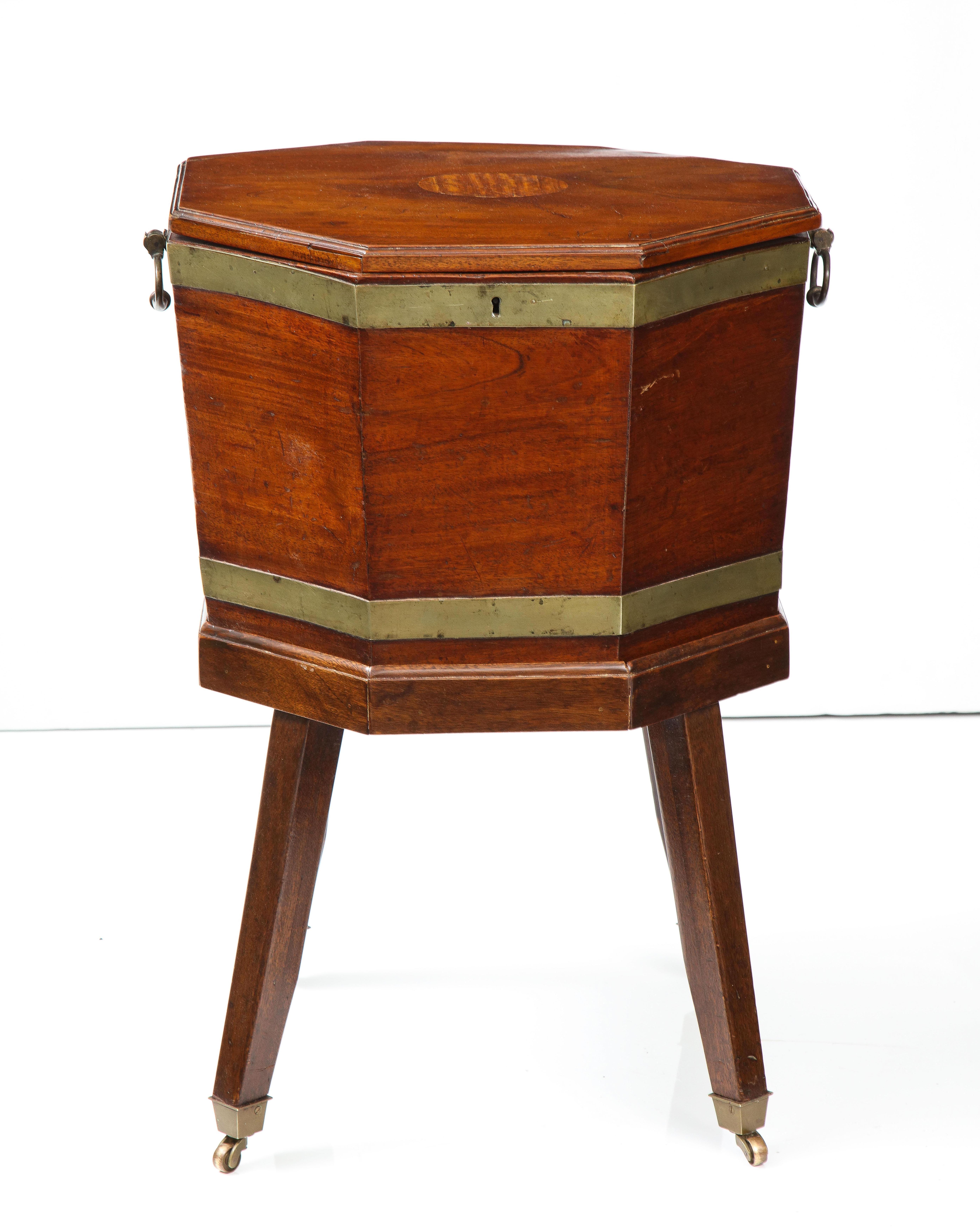 This handsome 19th-century mahogany cellarette is octagonal in shape and features beautiful brass banding, hardware and casters. Originally used to store wine and other libations, this piece can serve as storage or as a side or end table.