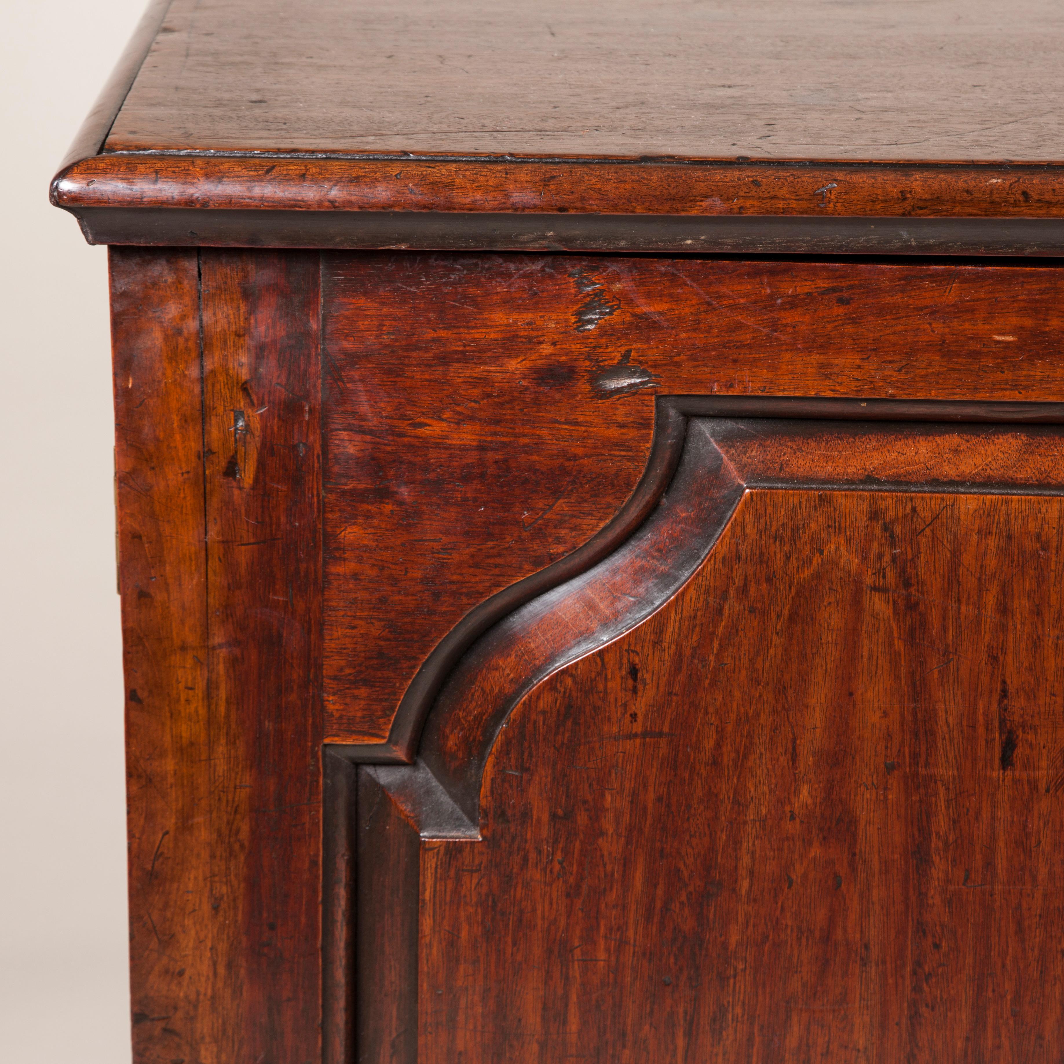 A low mahogany chest, the two doors with shaped raised and fielded panels enclosing shelves and open compartments, English, circa 1760.