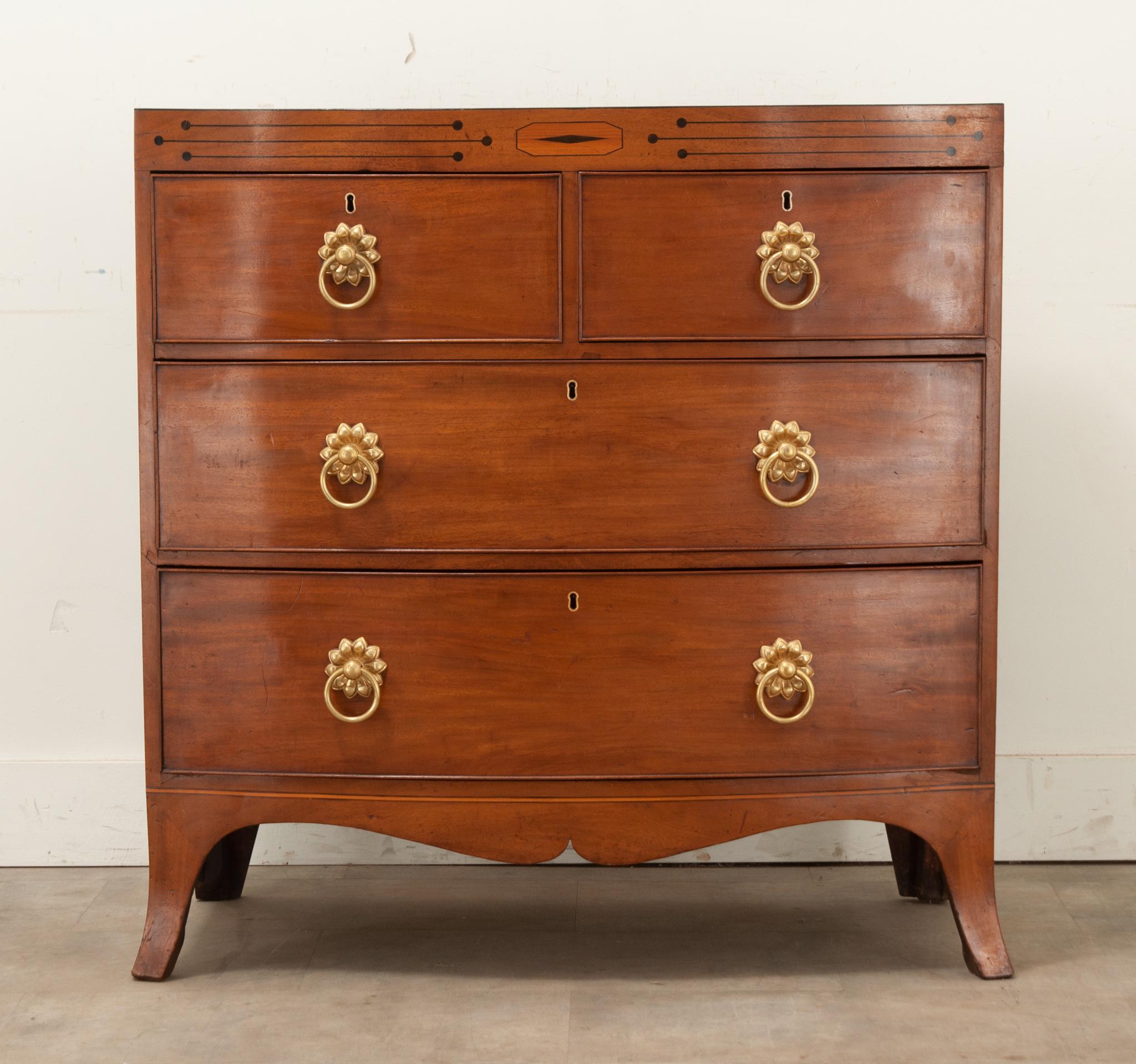 A stunning mahogany chest of drawers made in England. This four drawer chest features a linear composition with clean lines and a polished, finished presence. You’ll find geometric ebonized details above the drawers that set this little chest apart