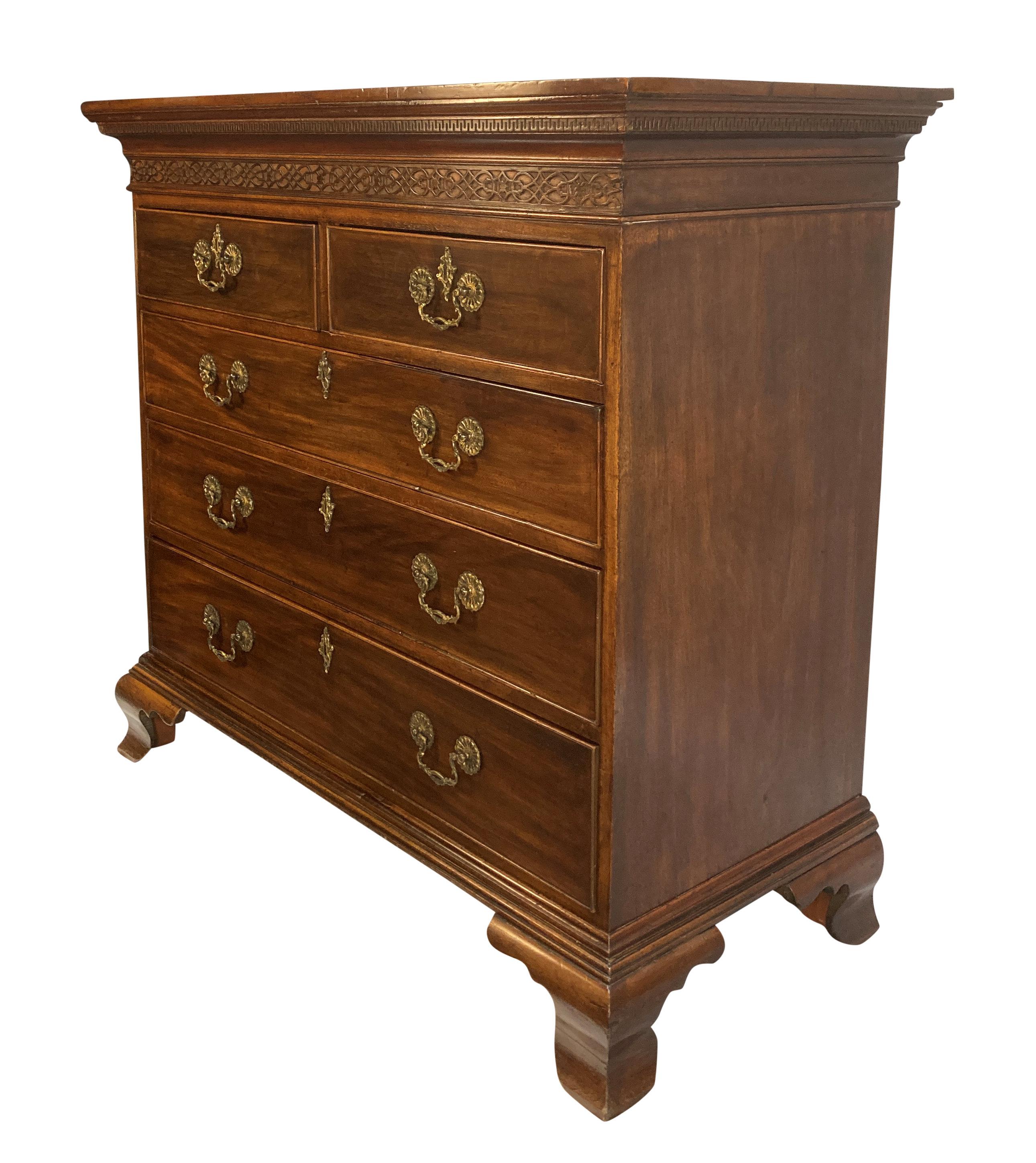 A finely proportioned English George III Chippendale period chest of drawers in mahogany. With a Greek key and fretwork upper frieze, each drawer with the original ornate handles and escutcheons.