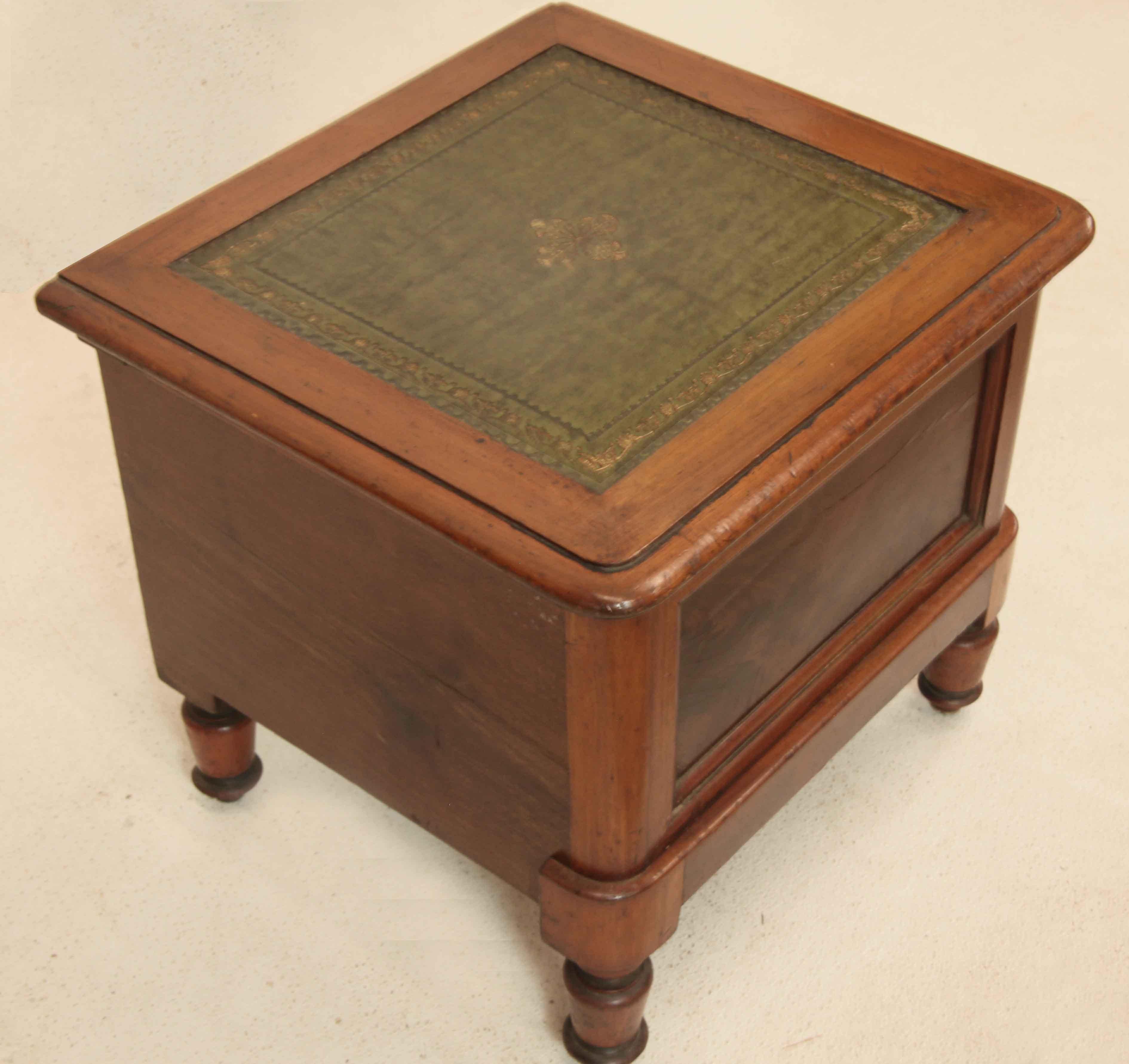 English mahogany commode, with tooled leather top,  front is veneered with flame mahogany; top lifts up on hinges;  interior has the original potty with turned wood lid.  The commode rests on turned feet.   