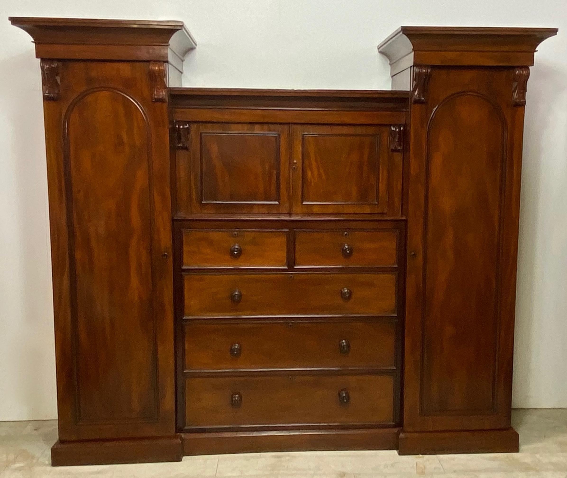 Handsome mahogany compactum / gentleman's dressing cabinet.
Having two arched panel wardrobe doors with fitted hanging bars, and a center cabinet over five drawers.
Excellent quality and condition.
England, mid 19th century.
This cabinet comes