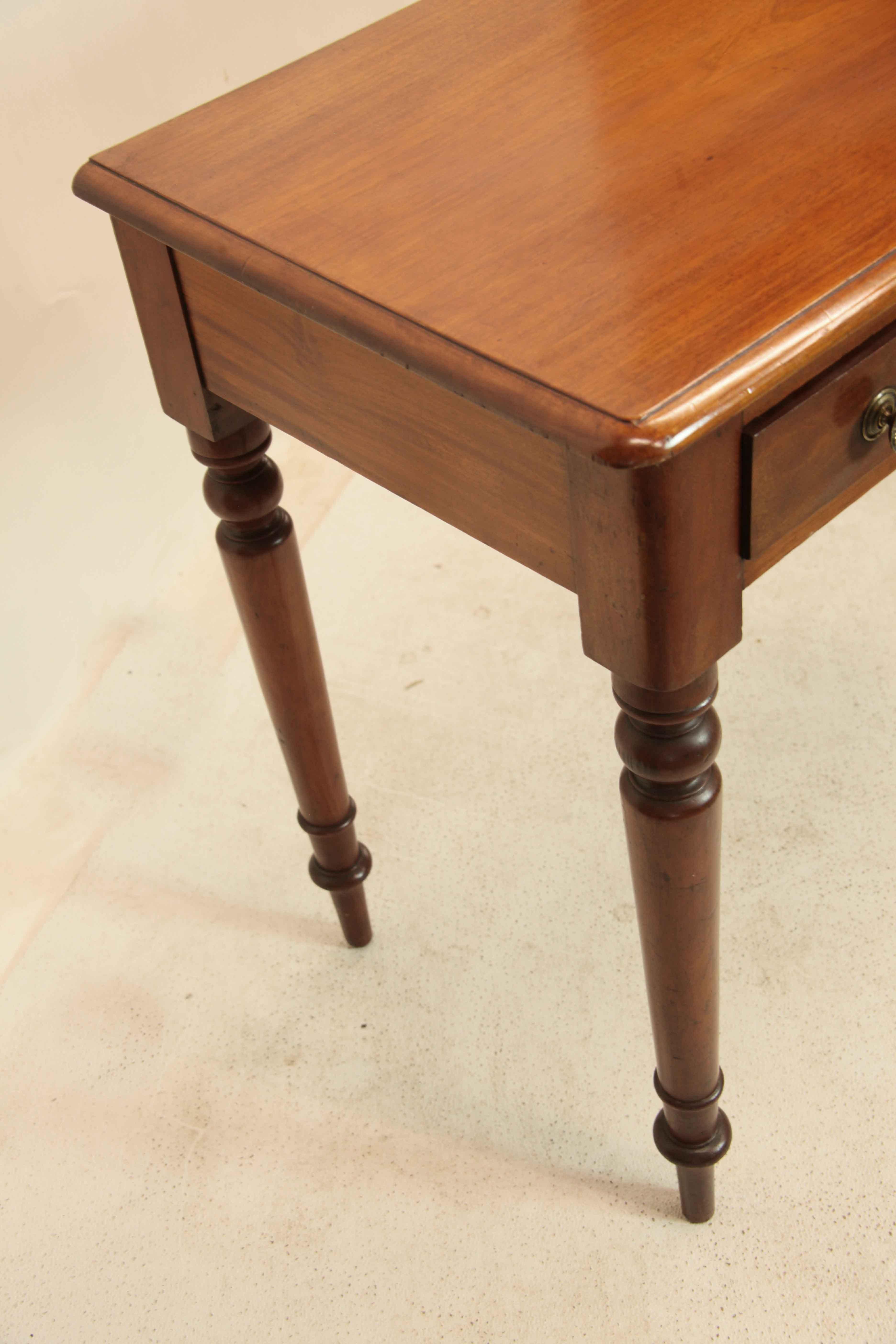 English mahogany console table, the top with molded edge has beautiful faded color and patina over two drawers with brass knobs and escutcheons, right hand drawer fitted for cutlery( needs new felt). mahogany secondary wood ; the legs are nicely