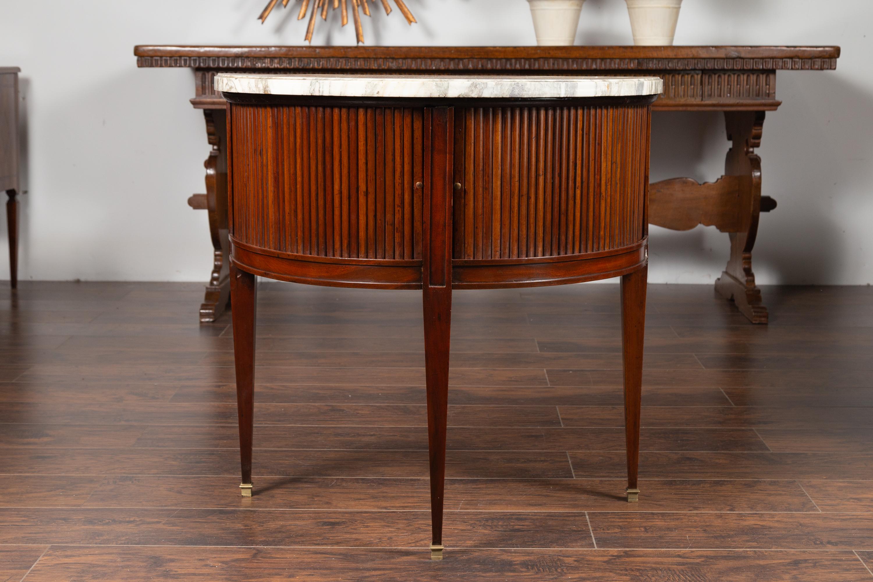 An English mahogany demilune cabinet from the mid-19th century, with reeded sliding doors and marble top. Born in England during the third quarter of the 19th century, this handsome demilune cabinet features a semi-circular variegated marble top