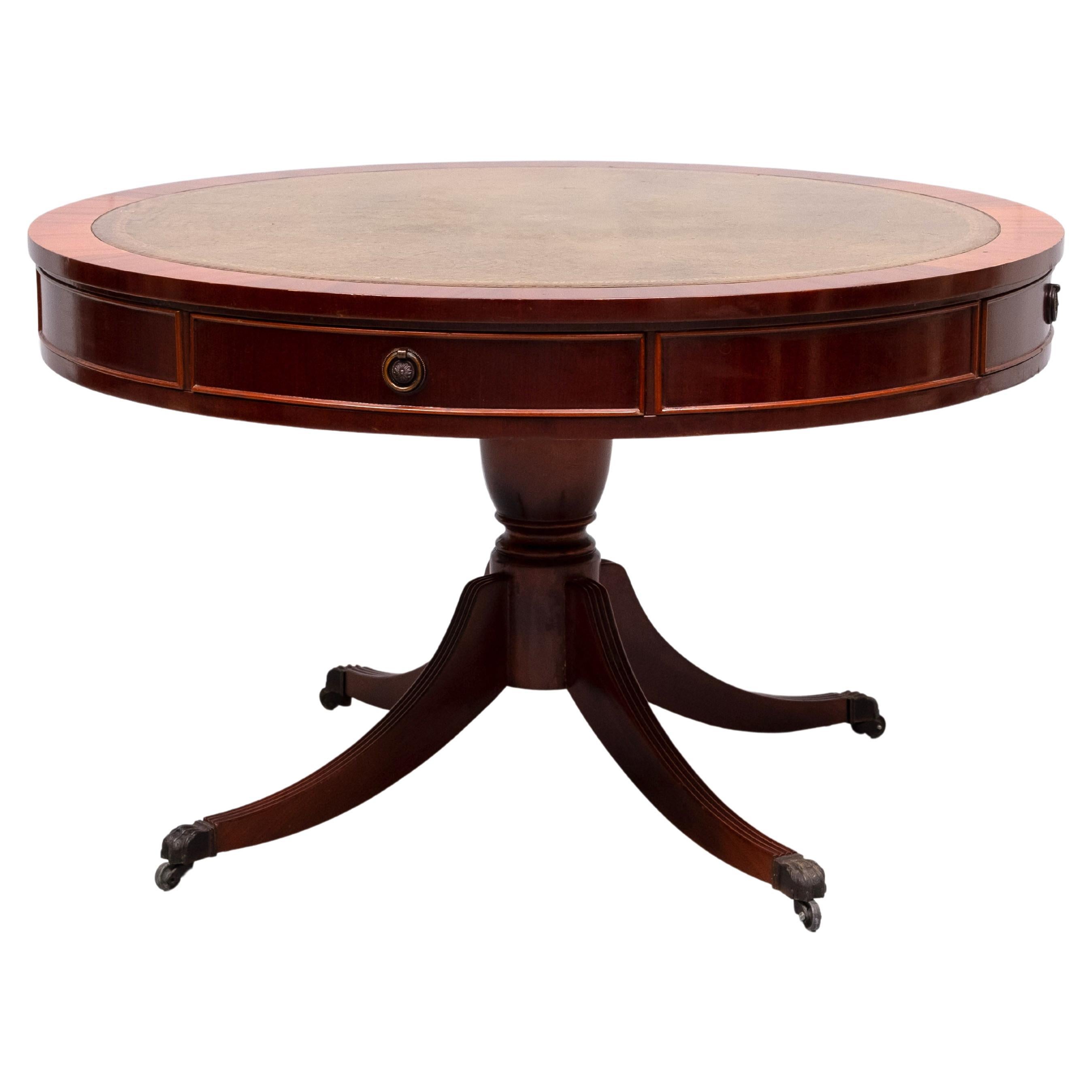 Beautiful mahogany  Drum table .Green Leather top ,comes with 
Gold embossed trim and there original brass box castors. 
The table features 4 working drawers .Nice condition and color .