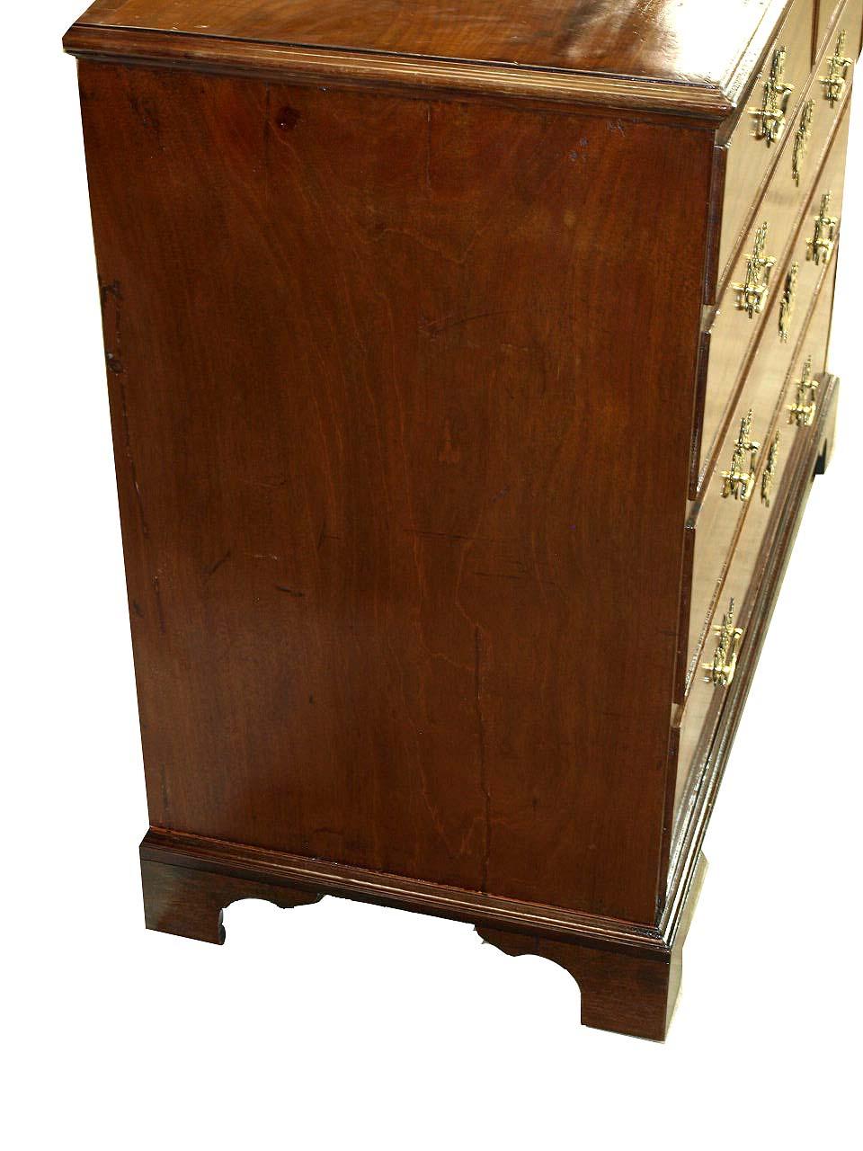 English mahogany five drawer chest, the top with beautiful figured grain and cross banded along the back edge with mahogany (see photo), the two over three graduated drawers with open fretwork brass pulls and escutcheons. The chest rests on bracket