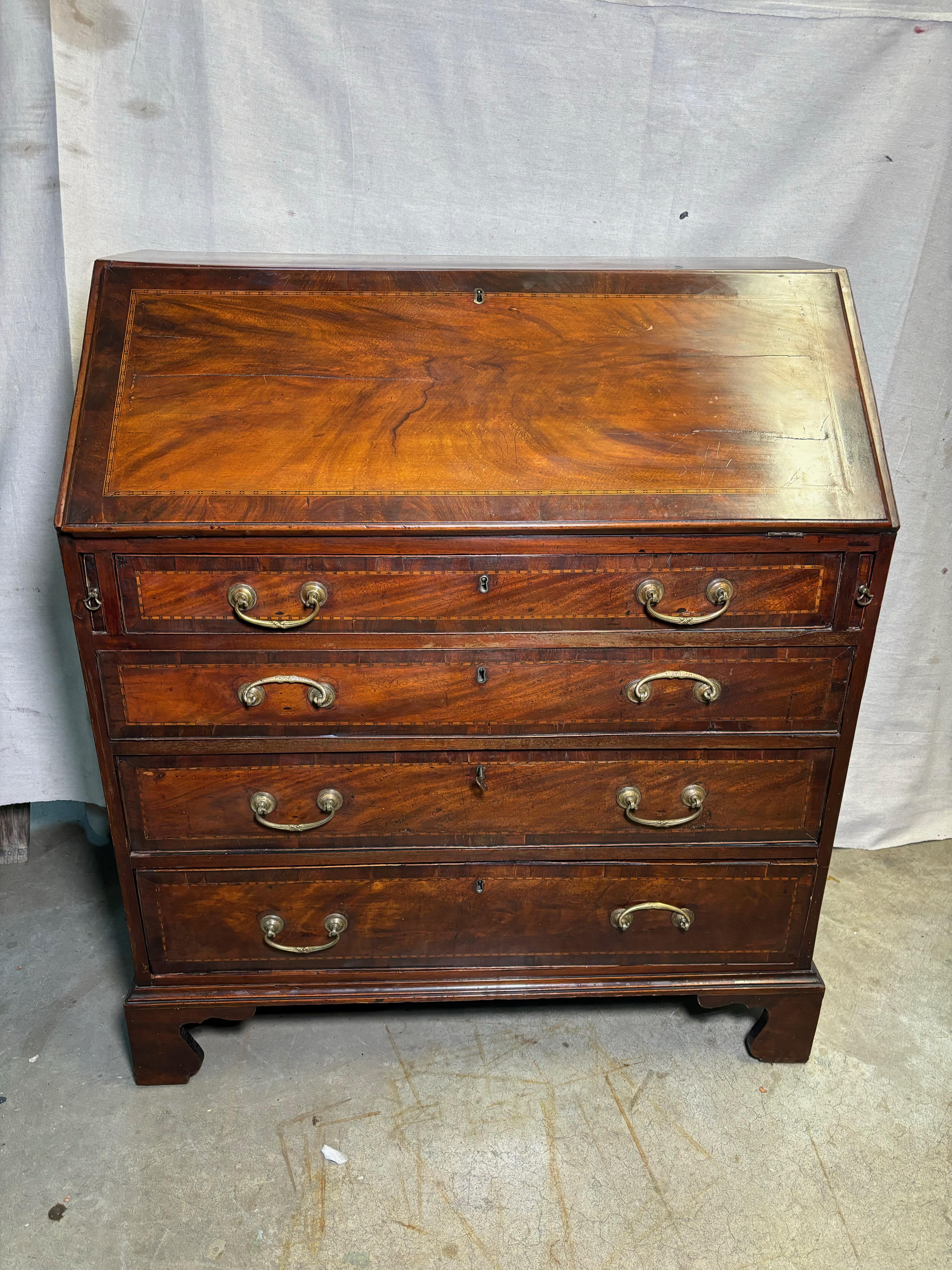 This charming late 18th-century George III period Mahogany bureau showcases exquisite craftsmanship and timeless appeal. The fall front opens to reveal a well-organized interior, featuring pigeonholes and drawers, along with a concealed well for