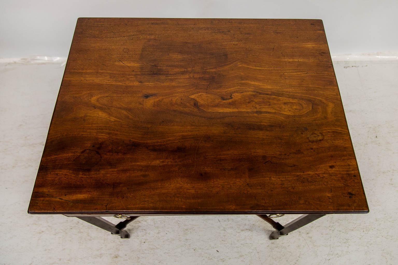This tea table has one working deep drawer with incised cockbeaded edges. It is finished on all four sides. The legs are chamfered on all four sides and have shaped lamb's tongues at the top and bottom of the chamfers. The legs are connected by a