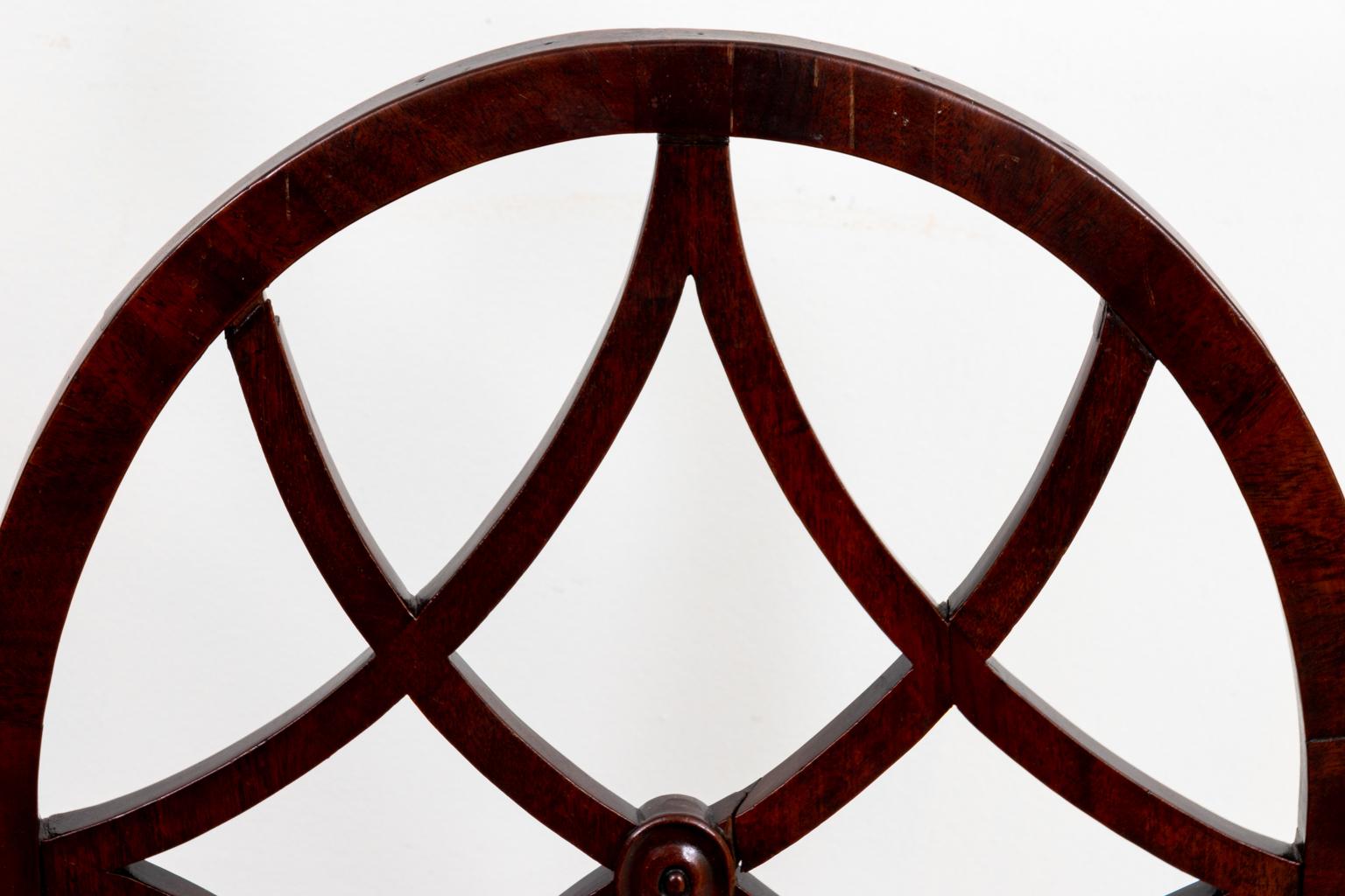 English mahogany hall chair with geometric tracery on the round seat back and quatrefoil tracery on the base. Please note of wear consistent with age including minor finish loss.