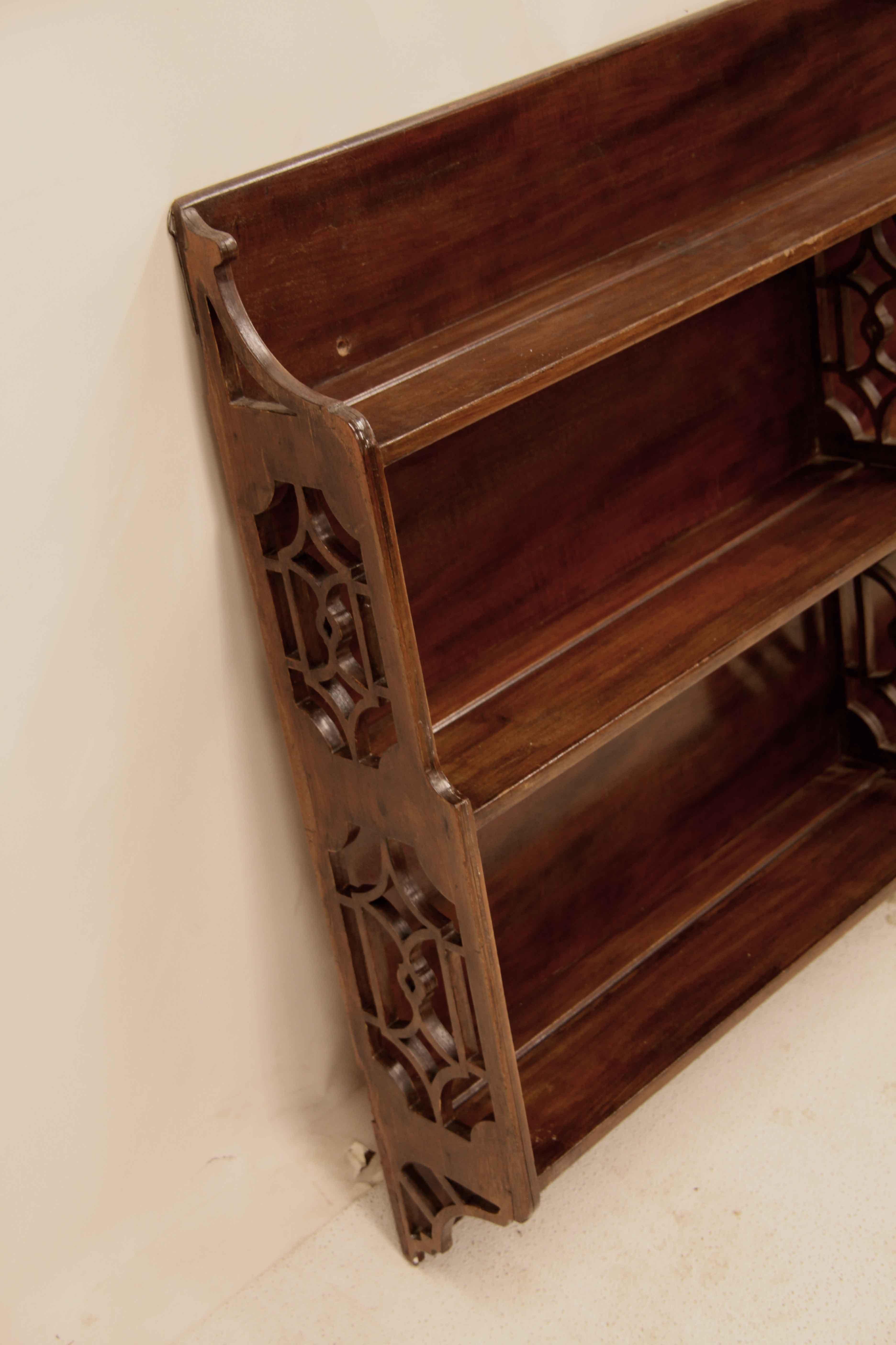 English mahogany hanging shelf, the decorative feature of this shelf and what will make a statement on the wall is the reticulated open design of the  ends and center support.  The top shelf is 5'' deep , the lower two shelves are 6'' deep.  The