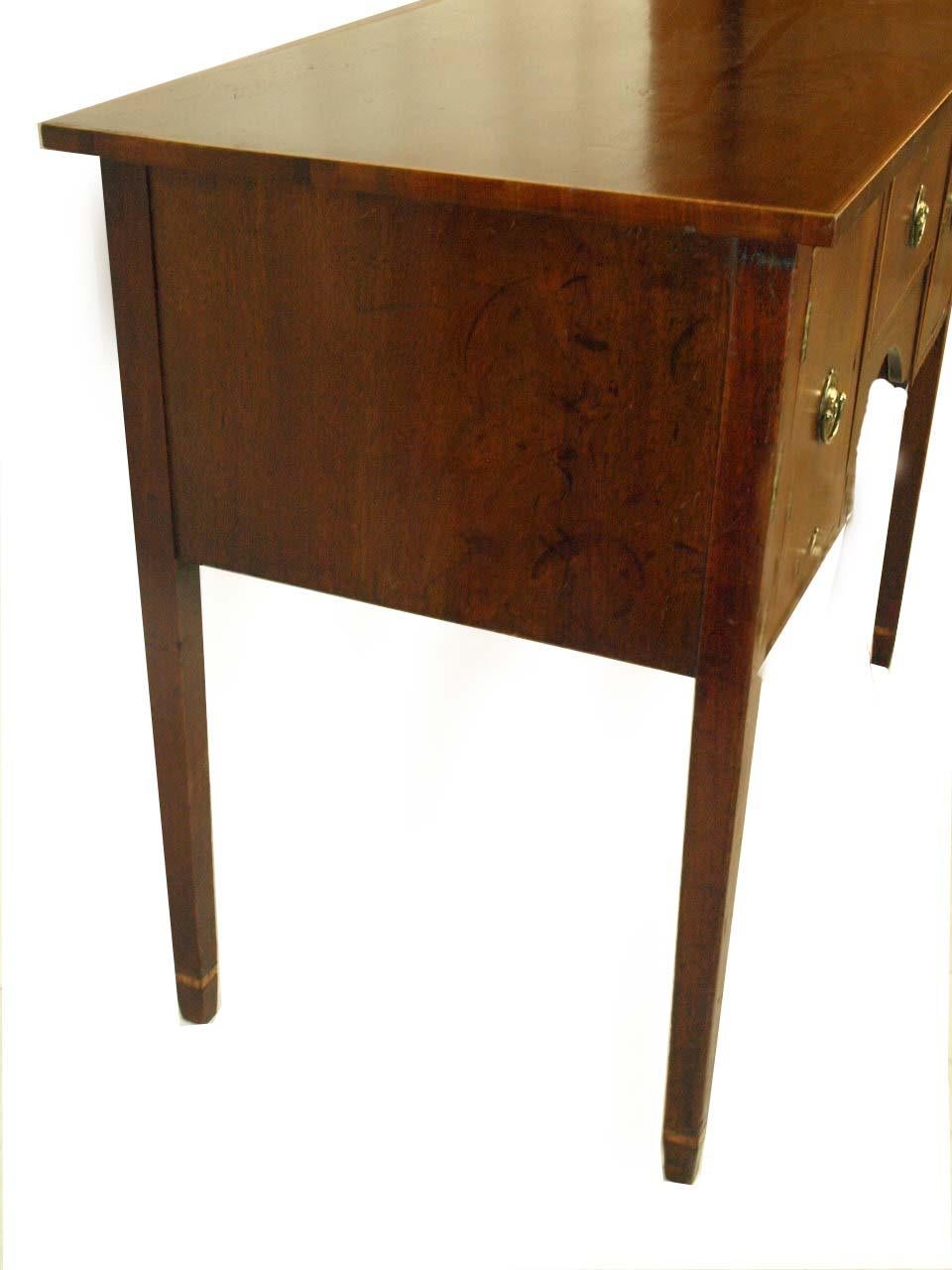 English mahogany Hepplewhite server with bands of inlay around the top, drawer and doors; the tapered legs banded with inlay , the concave apron with boxwood string inlay; the brass pulls appear to be antique, but are not original., notice the