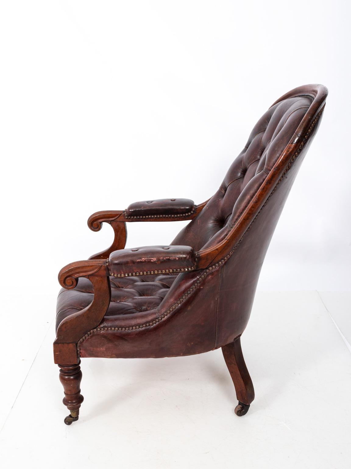 English mahogany armchair with tufted leather upholstery on casters, circa 1860s-1880s.