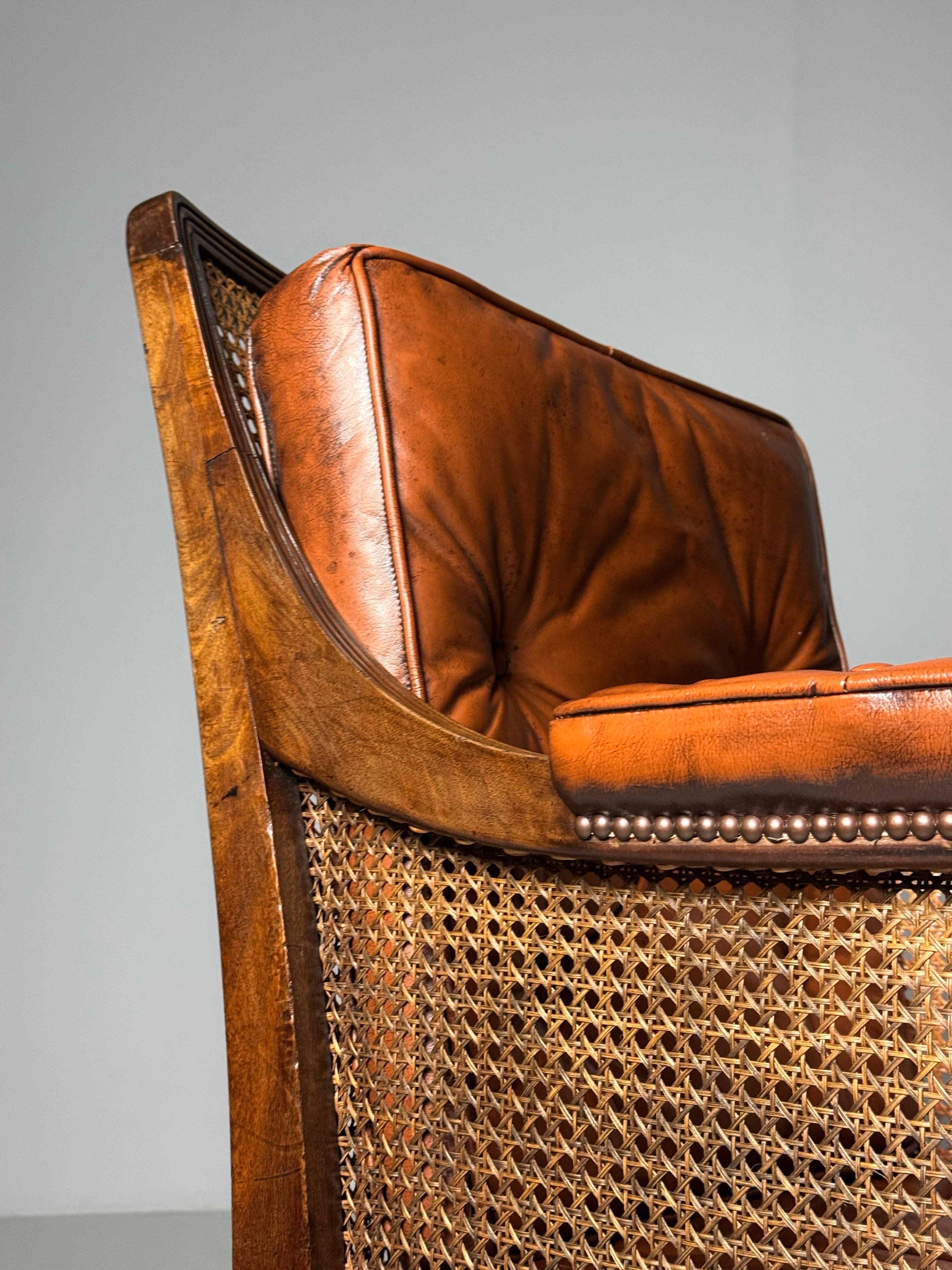 Exceptionally beautiful English Library Bergère chair.

Executed in mahogany. Standing on brass castors. Original from England, William IV Period (1835).

In very good condition. Leather and wicker seat are not from this period but replaced